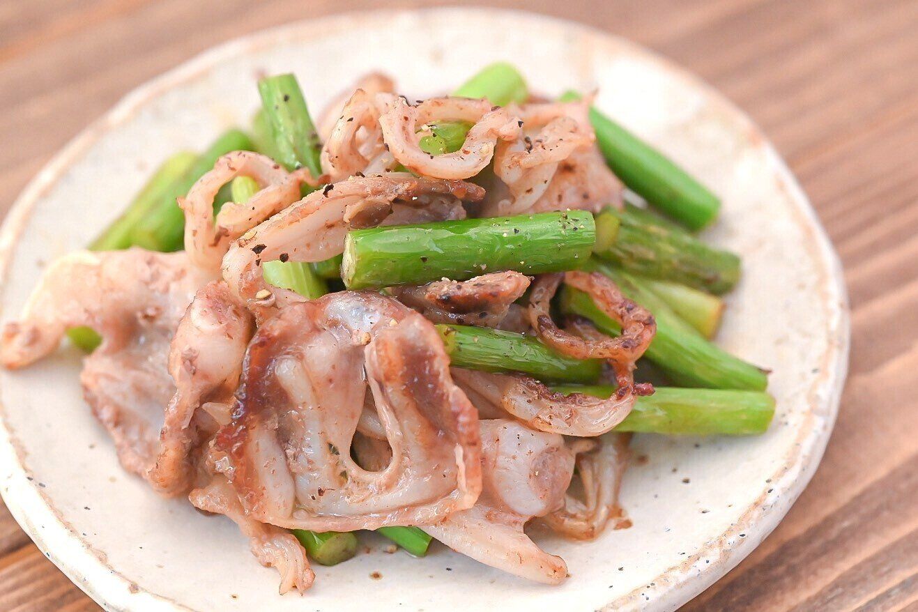 皿に盛られた豚なんこつとにんにくの芽のしょうゆ炒め