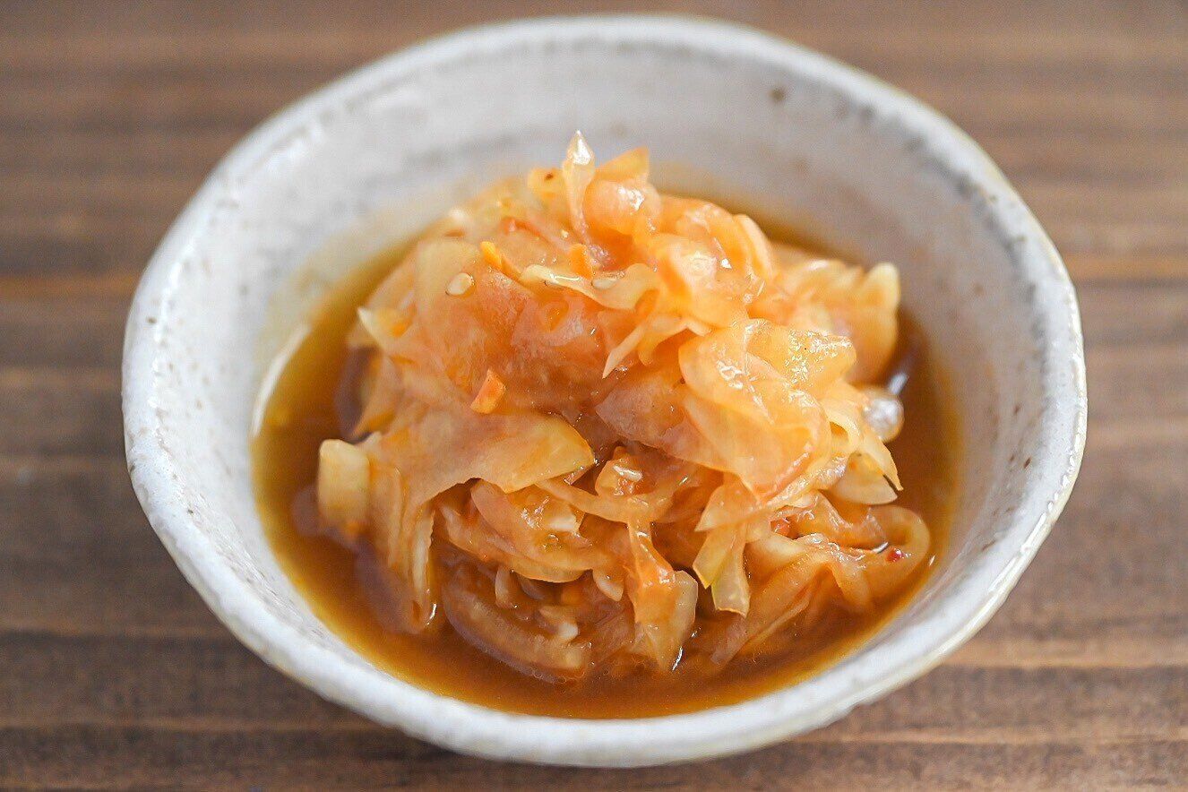 白い皿に盛られた玉ねぎの食べるナッツソース和え