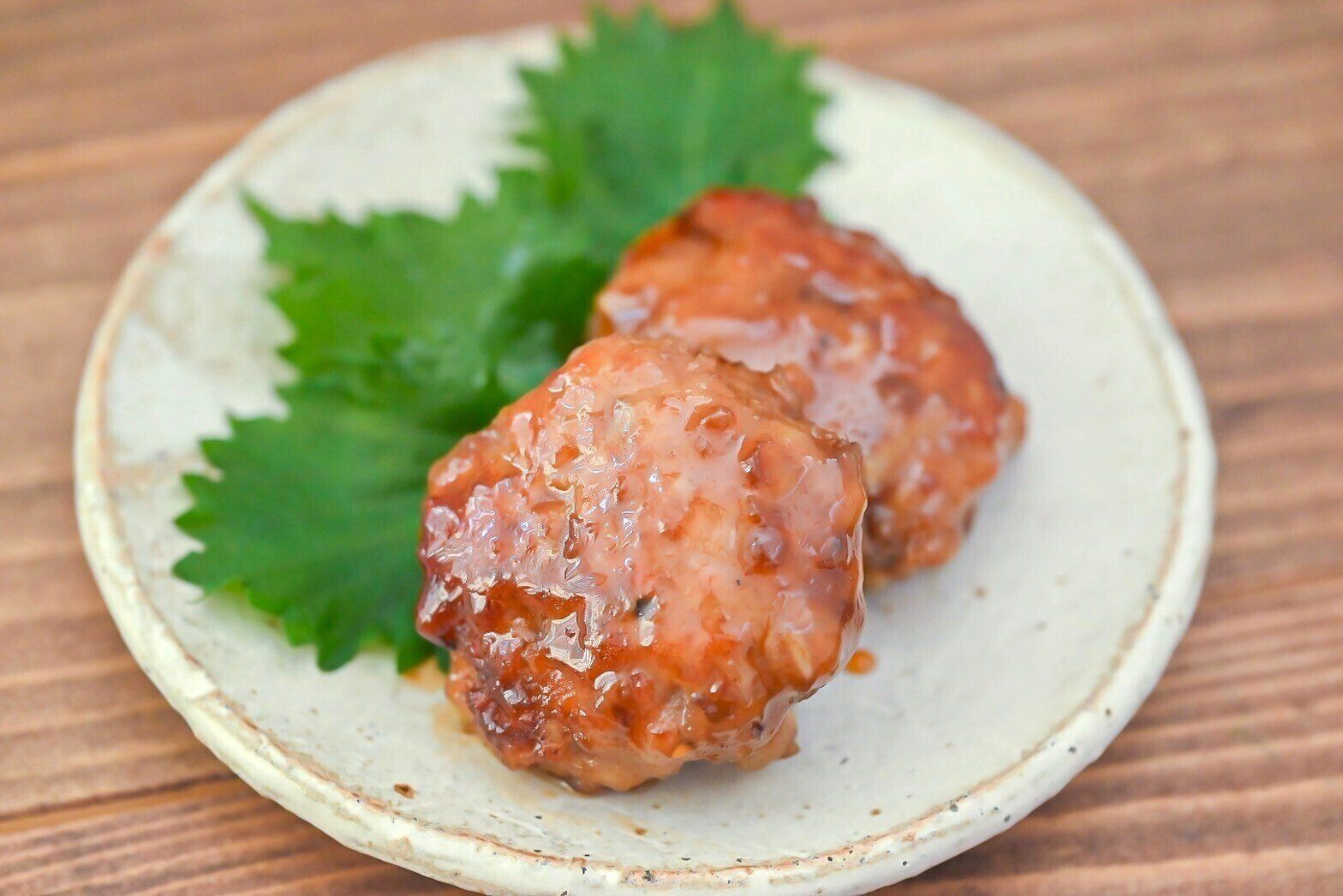 皿に盛られた大葉を添えたナンコツ入り豚つくね