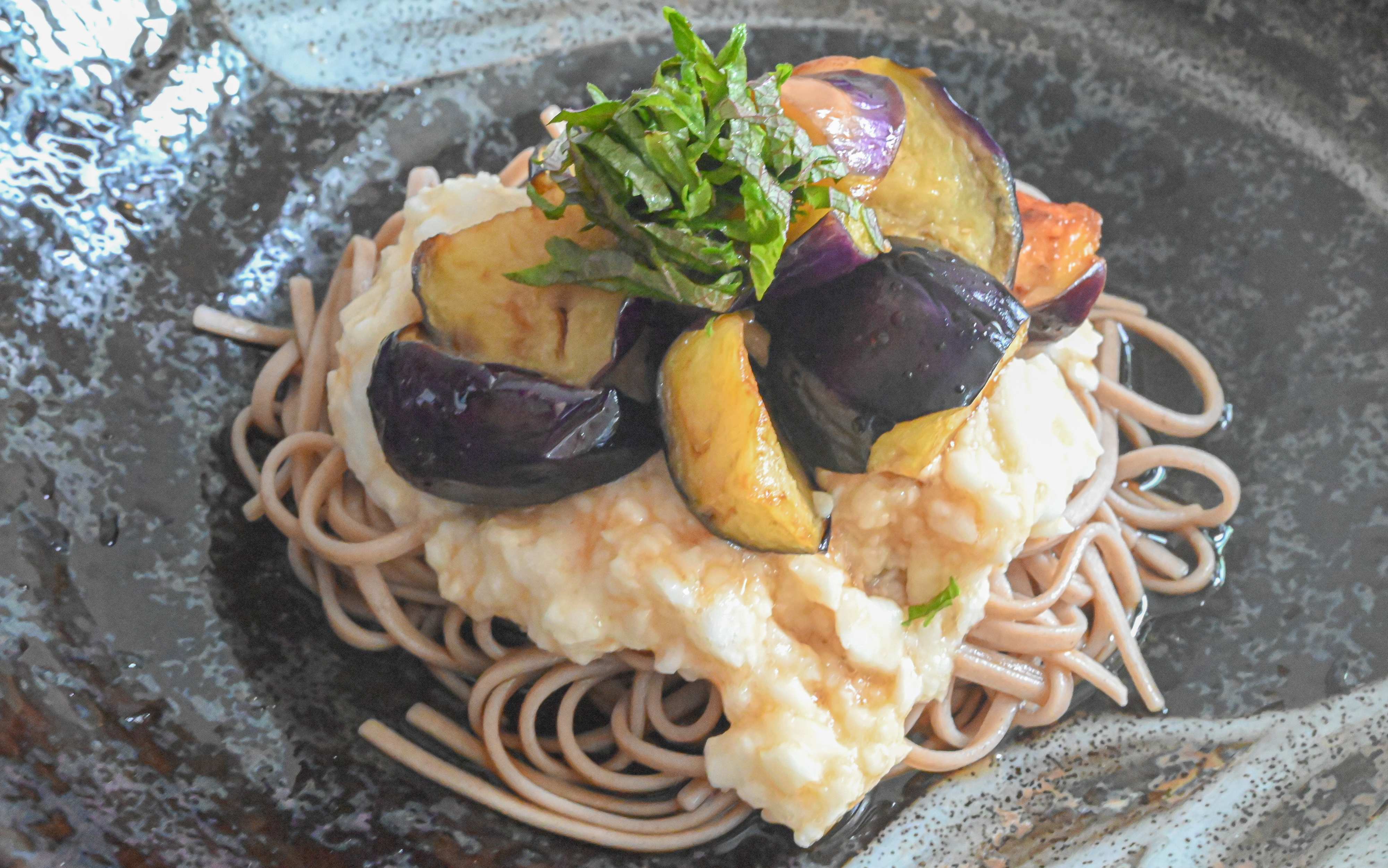 黒い皿に盛られた揚げなすのとろろそば