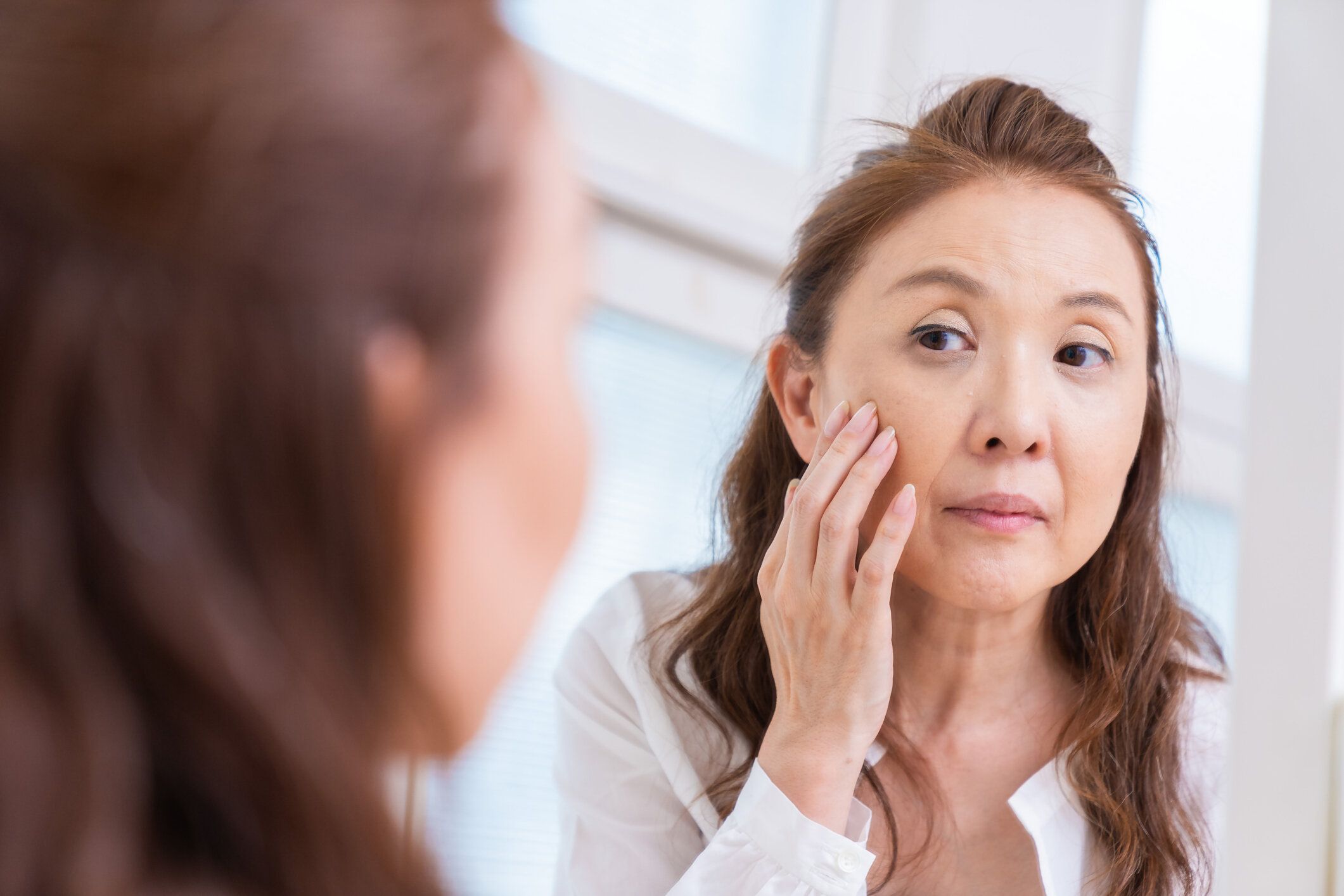 鏡を見る年上の女性