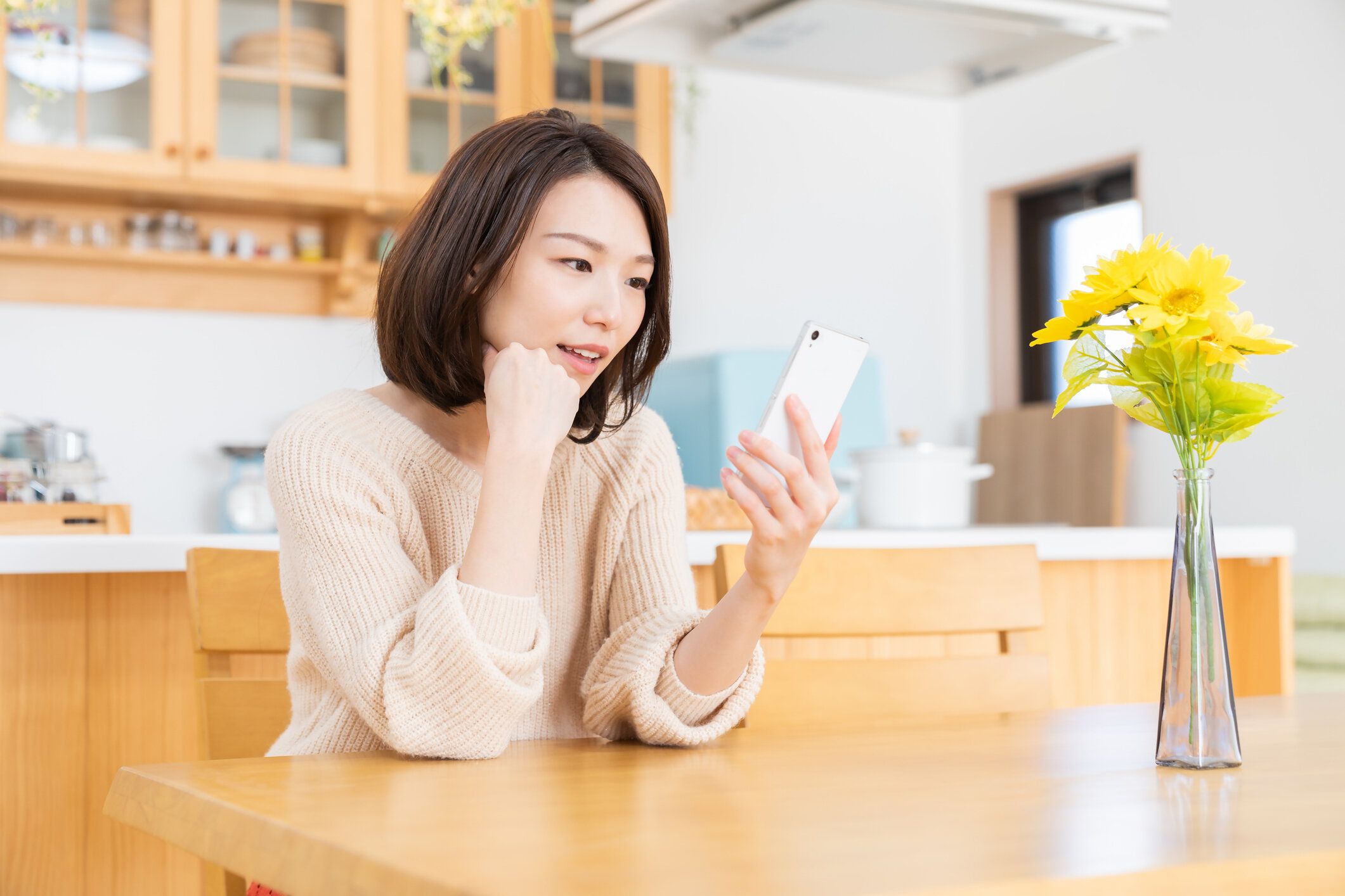 スマート フォンを見て魅力的なアジアの女性、考える、