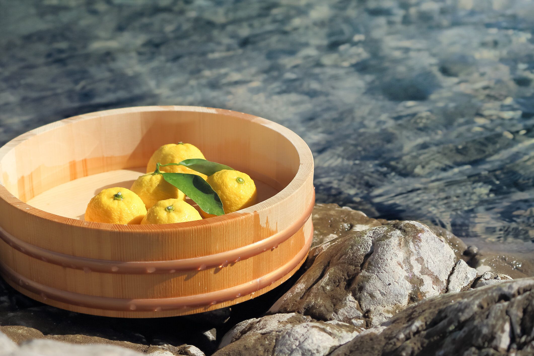 露天風呂に葉っぱと浴槽のあるゆず。お湯のイメージは暖かくリラックスできます。