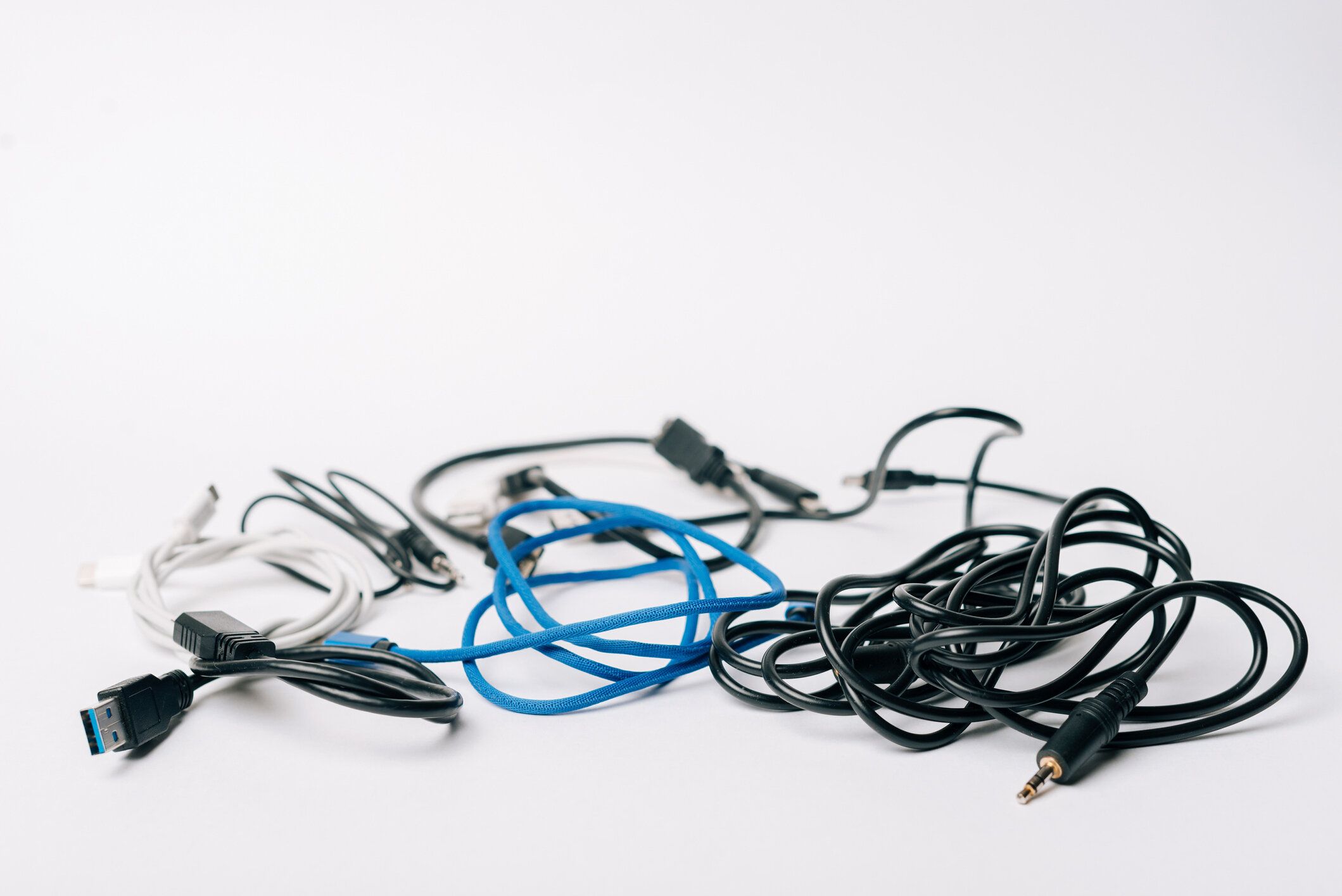 白いテーブルの上の多くのコンピュータケーブルの写真