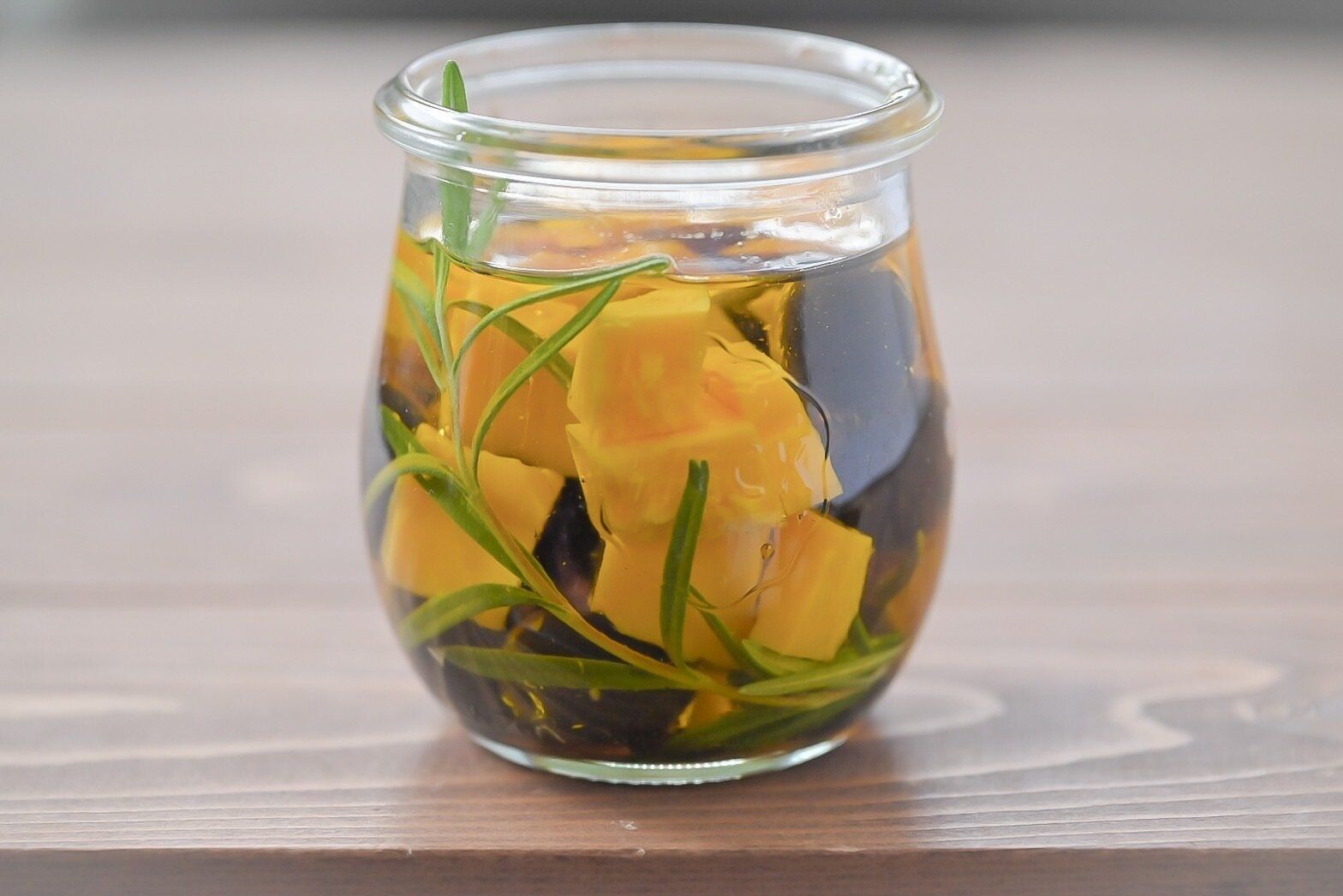 ガラス容器に入ったオリーブとチーズのオイル漬け