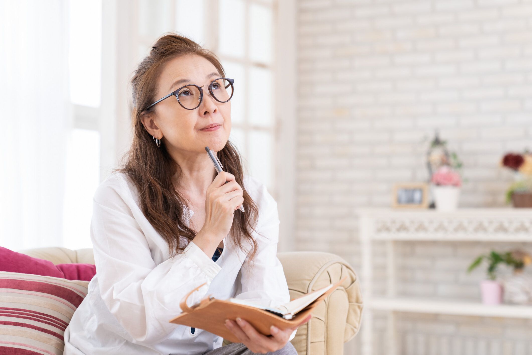 スケジュールブックに記入する年長の女性は、考えます