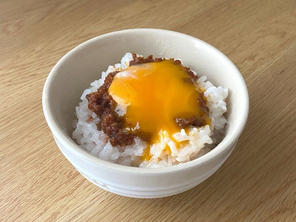 白米の上にのせたご飯で汁なし坦坦と卵黄