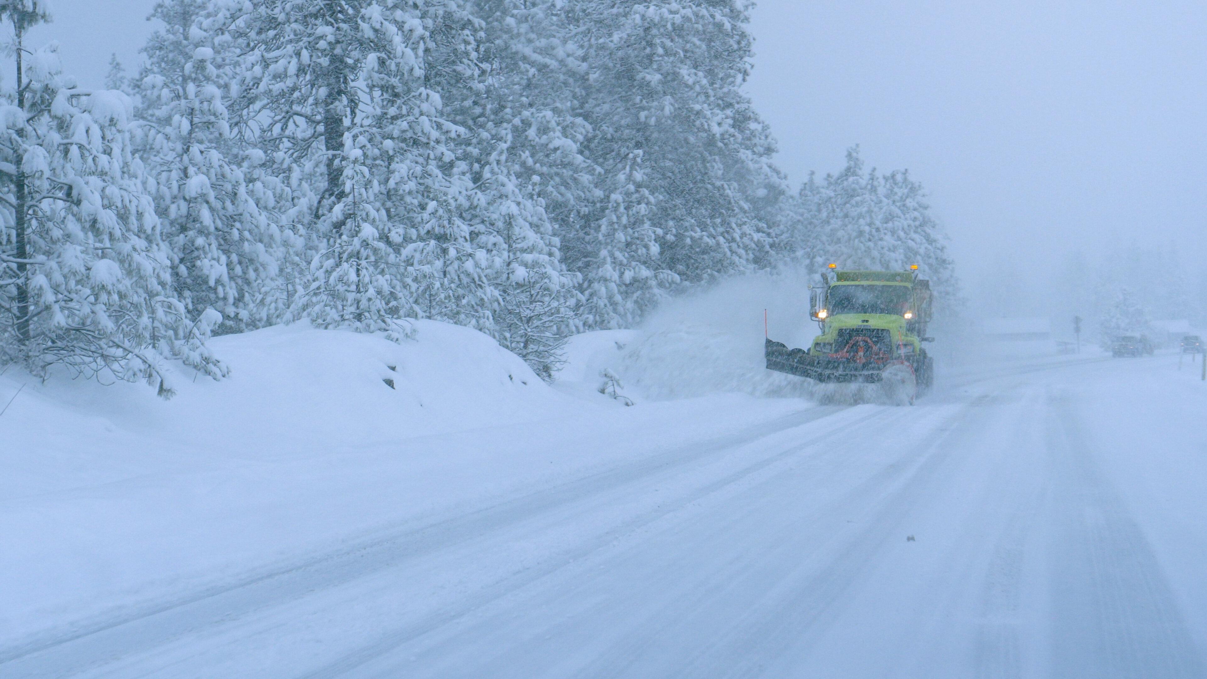 クローズアップ:トラックは恐ろしい吹雪の間に雪の田舎道を耕します。