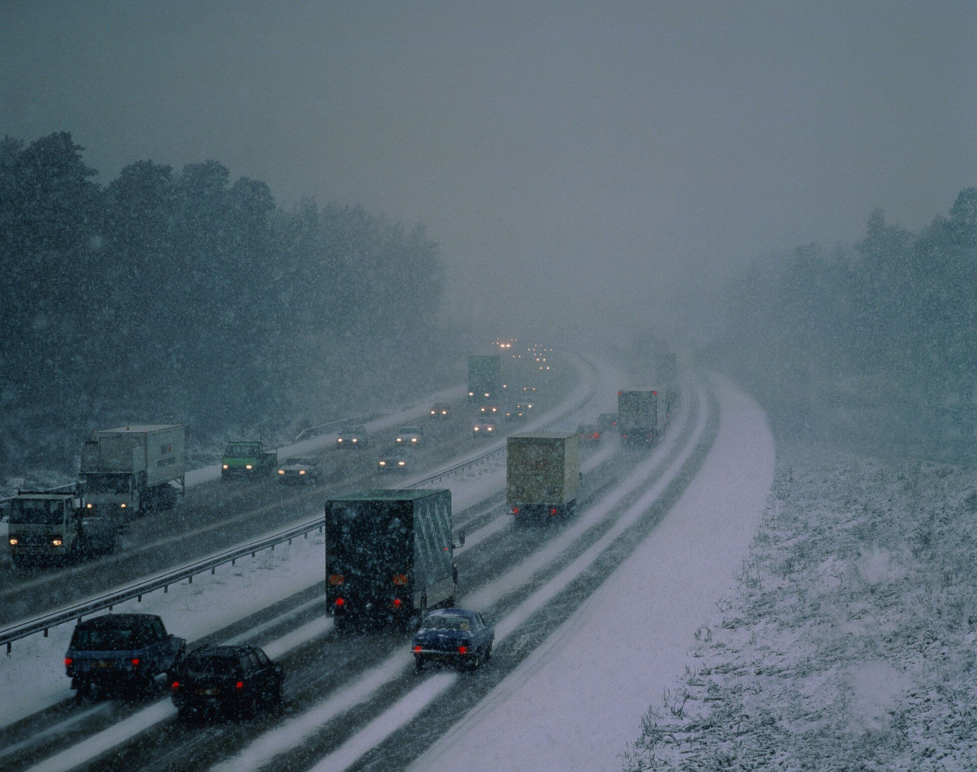 吹雪の道路と自動車の列