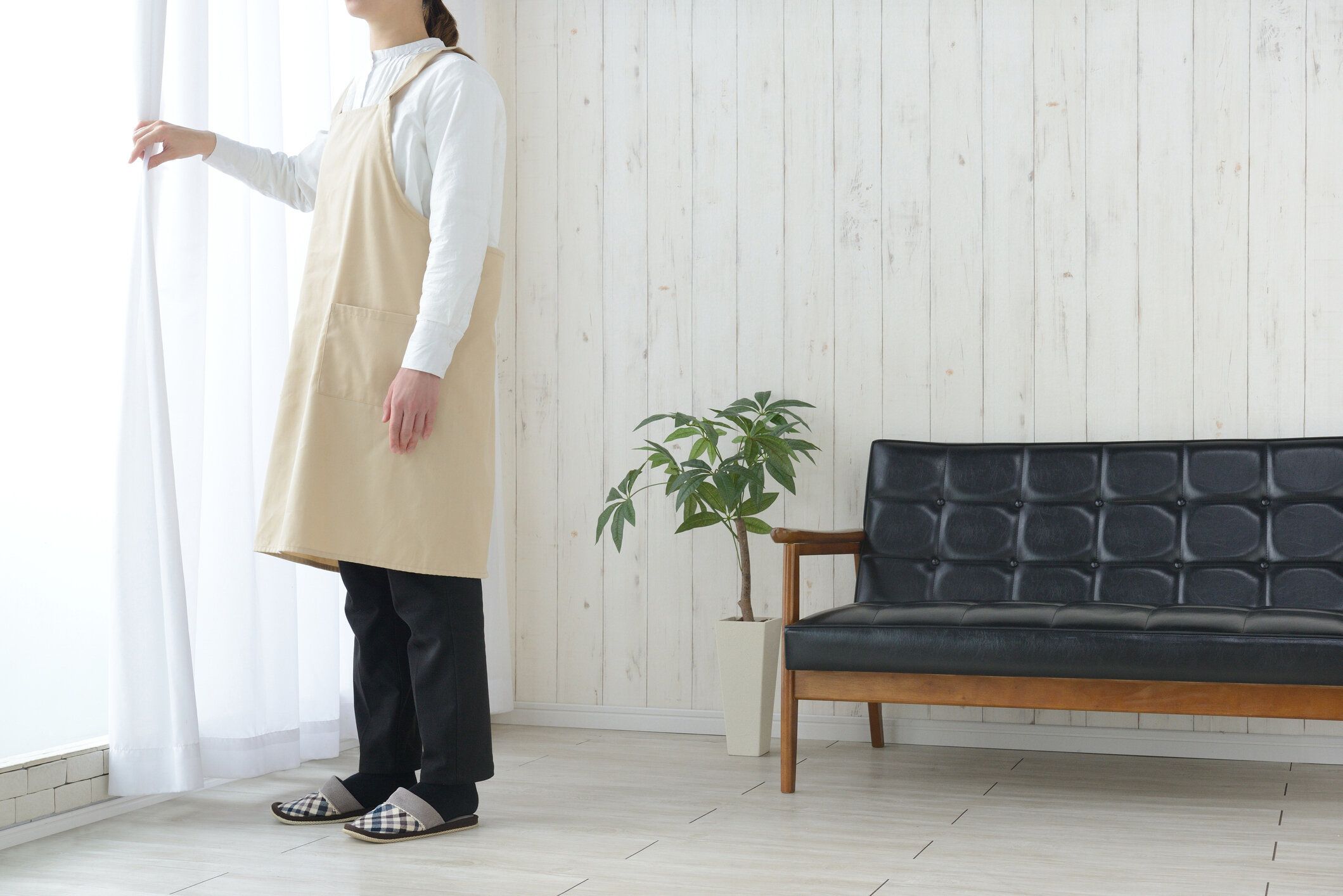 リビングルームでの女性のオープニングカーテン