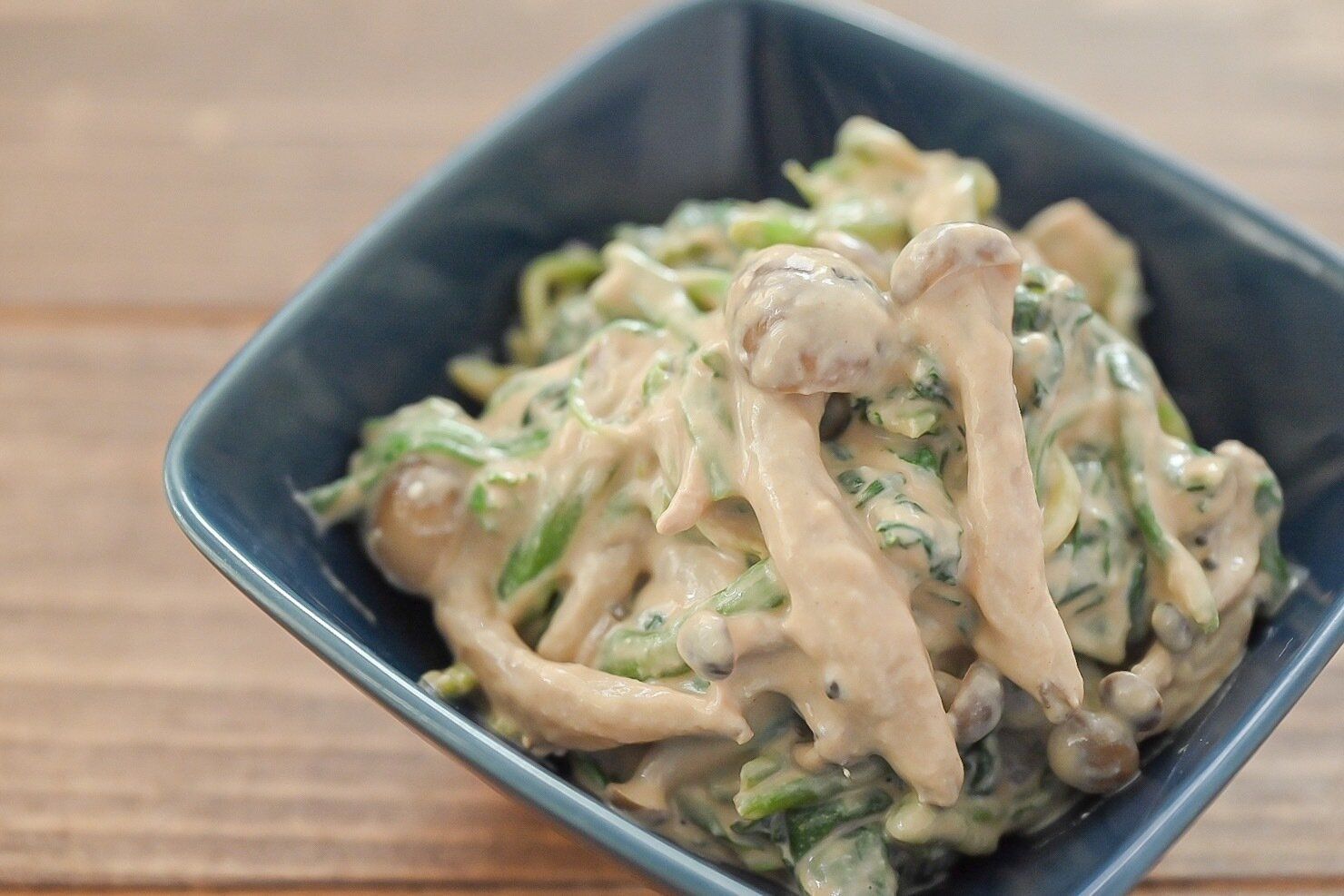 青い皿に盛られたしめじとほうれん草の白和え