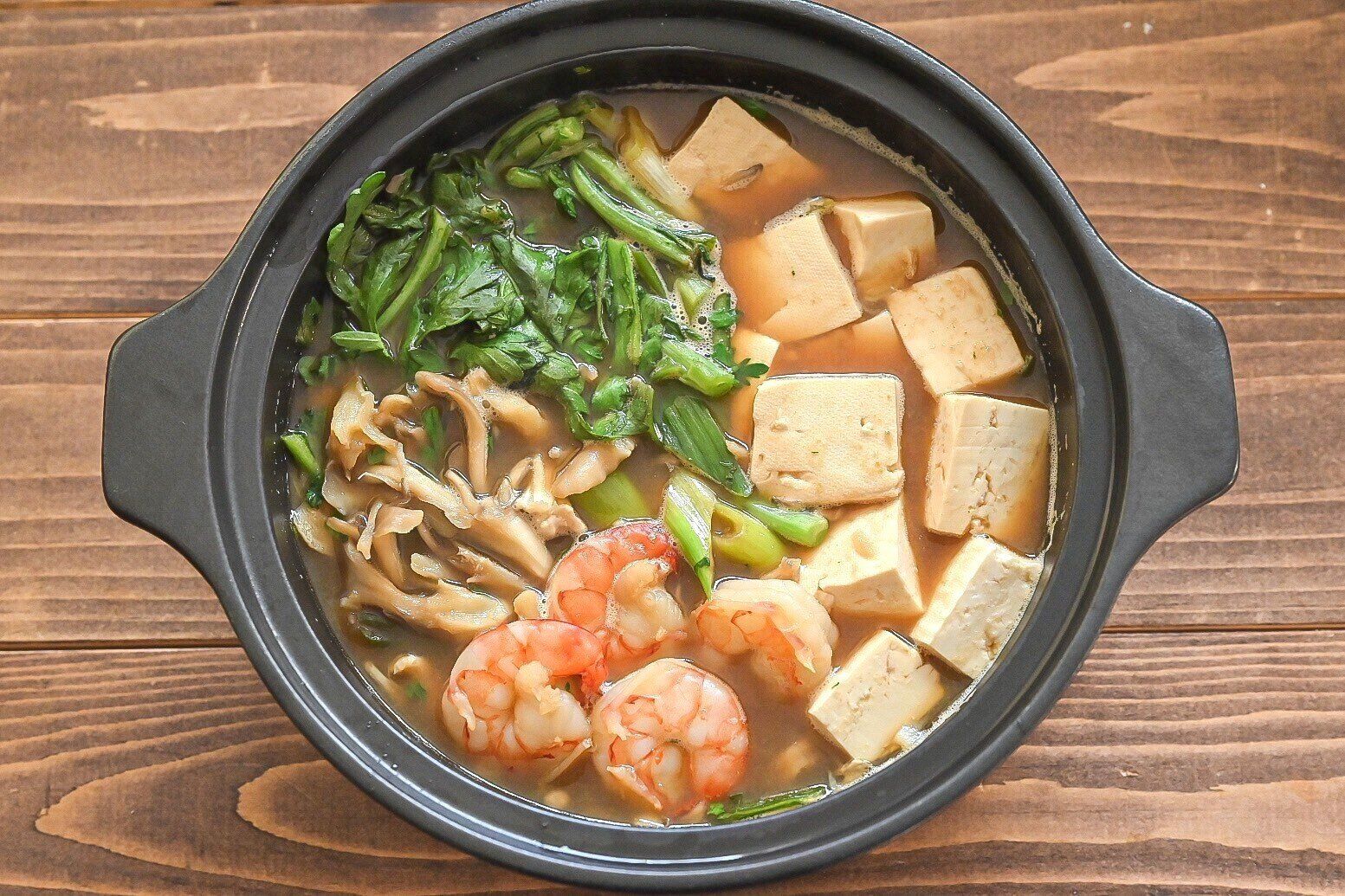 黒い鍋に入った完成した海老だし味噌鍋