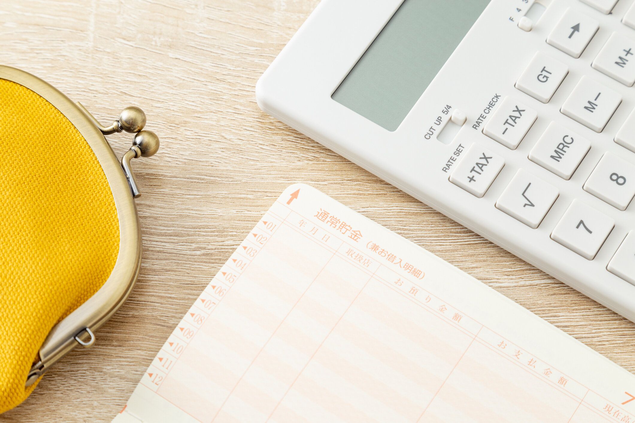 机の上には財布、電卓、通帳があります。
