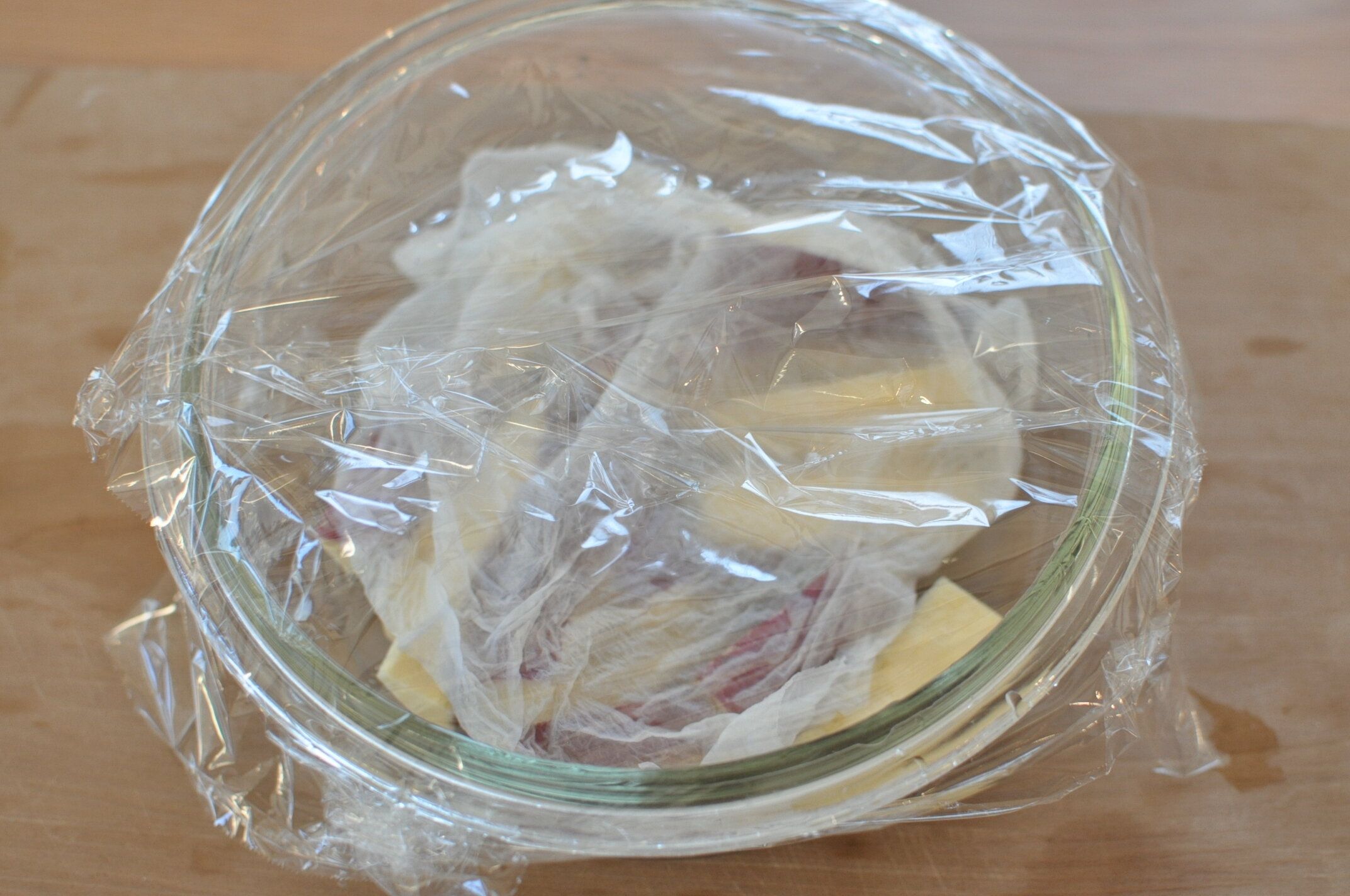 さつまいもに濡らしたキッチンペーパーをかぶせ、耐熱容器に入れてラップをかけた様子