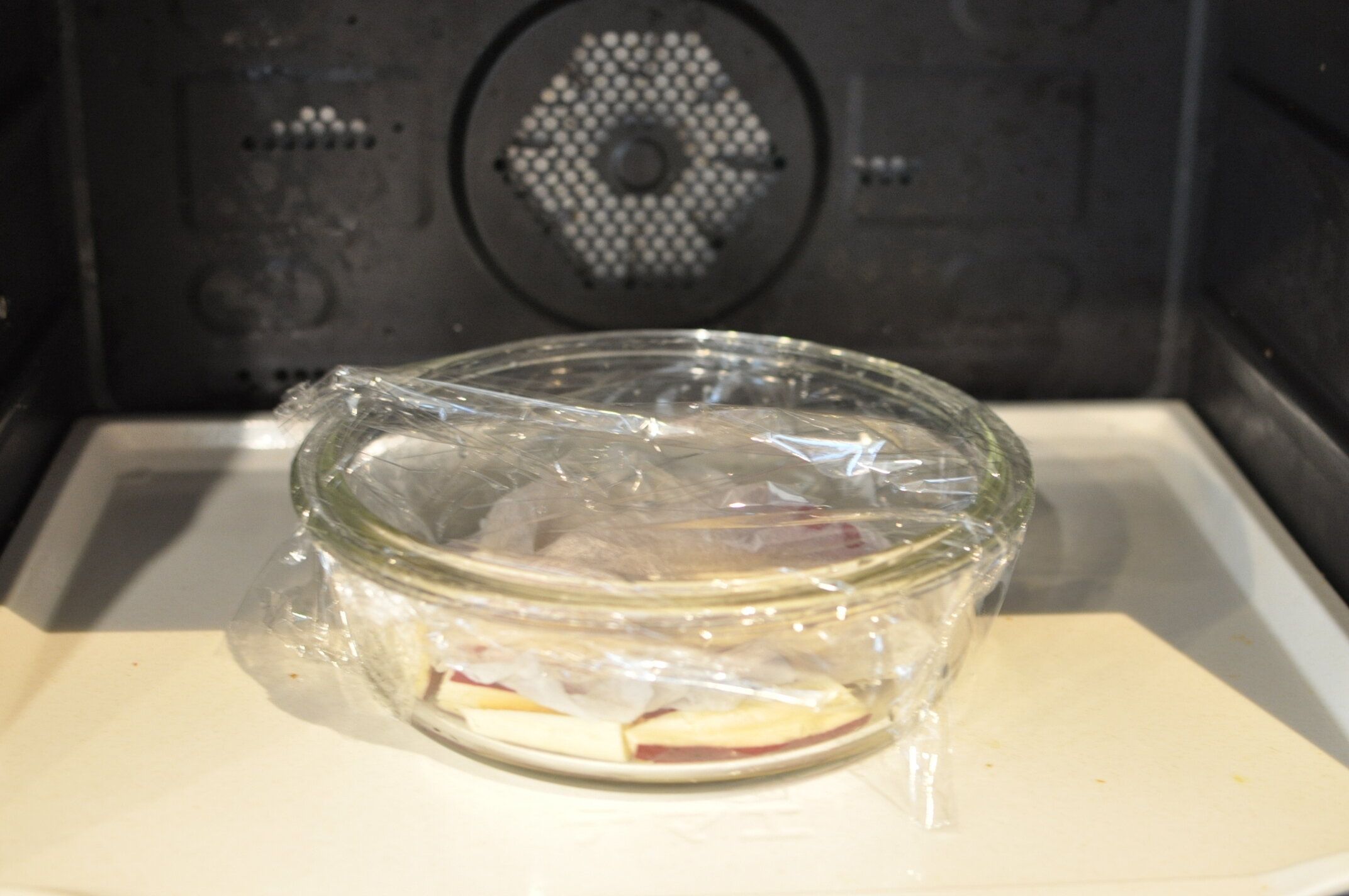 耐熱容器に入れたさつまいもを電子レンジで加熱する様子