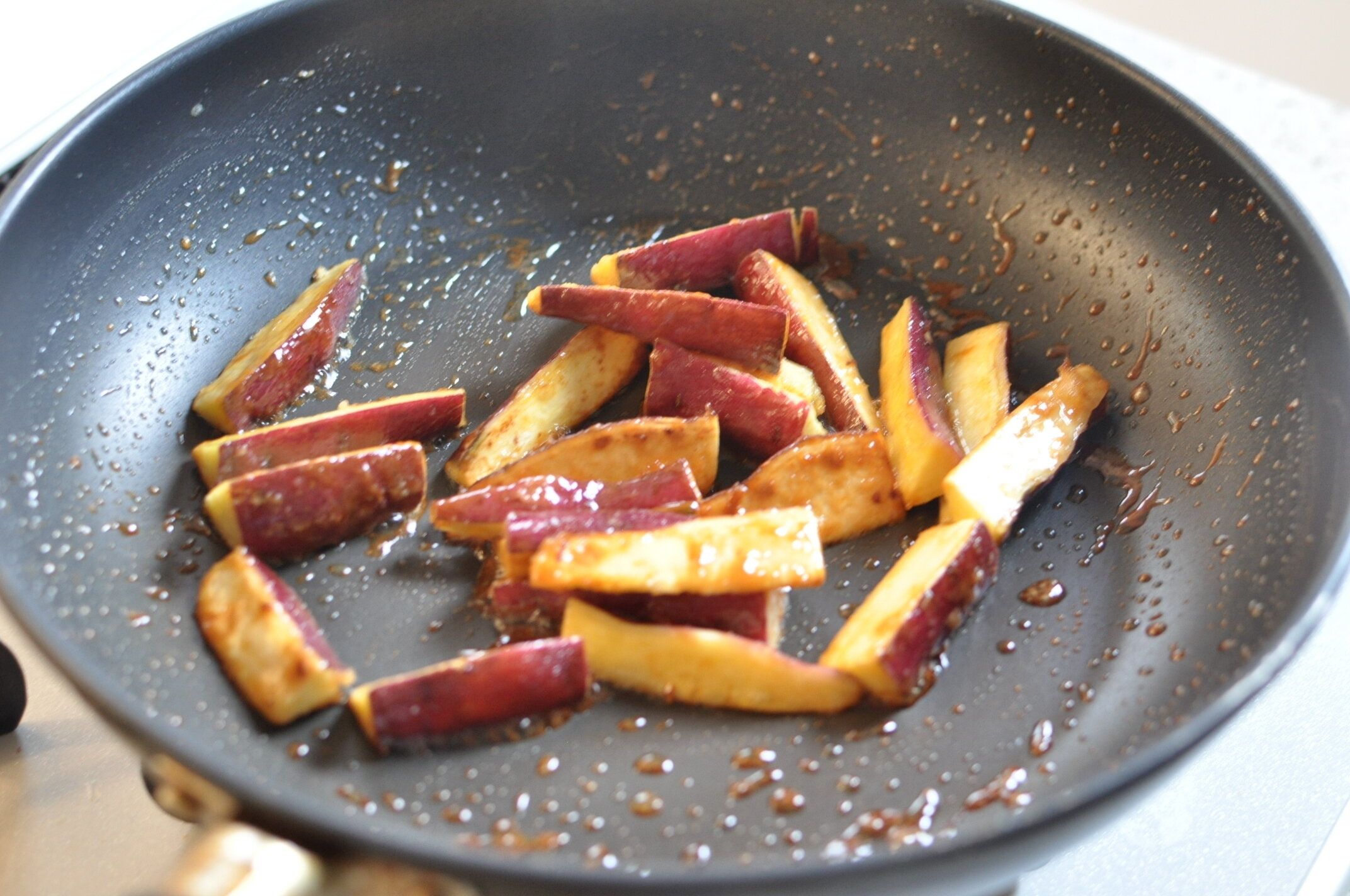 キャラメル状になったソースをさつまいもに絡ませる様子