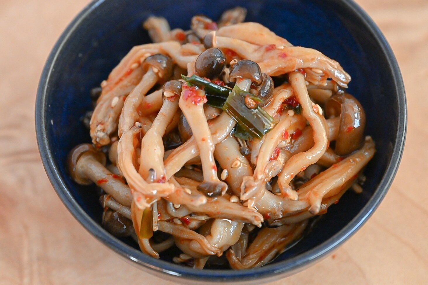 青い皿に盛られたしめじの旨辛ニラだれ和え