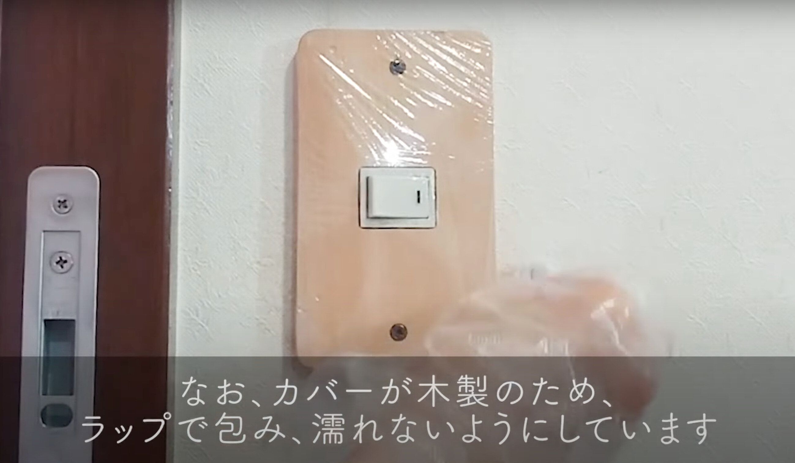 木製のコンセントカバーをラップで包む