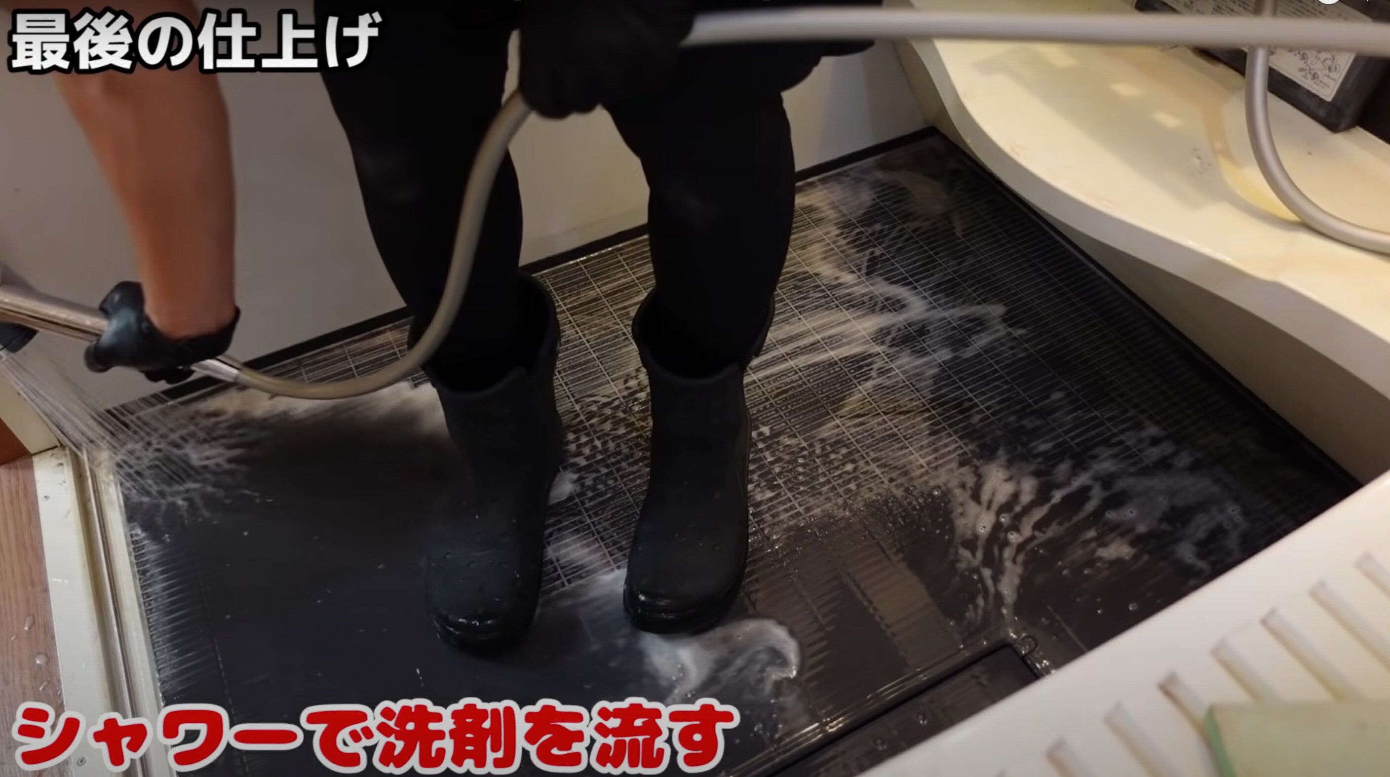 お風呂の床をシャワーで洗剤を流す