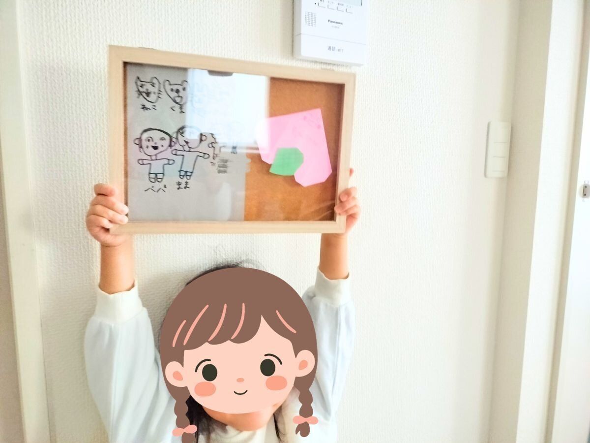 自分の作品が入った額を持って嬉しそうな娘