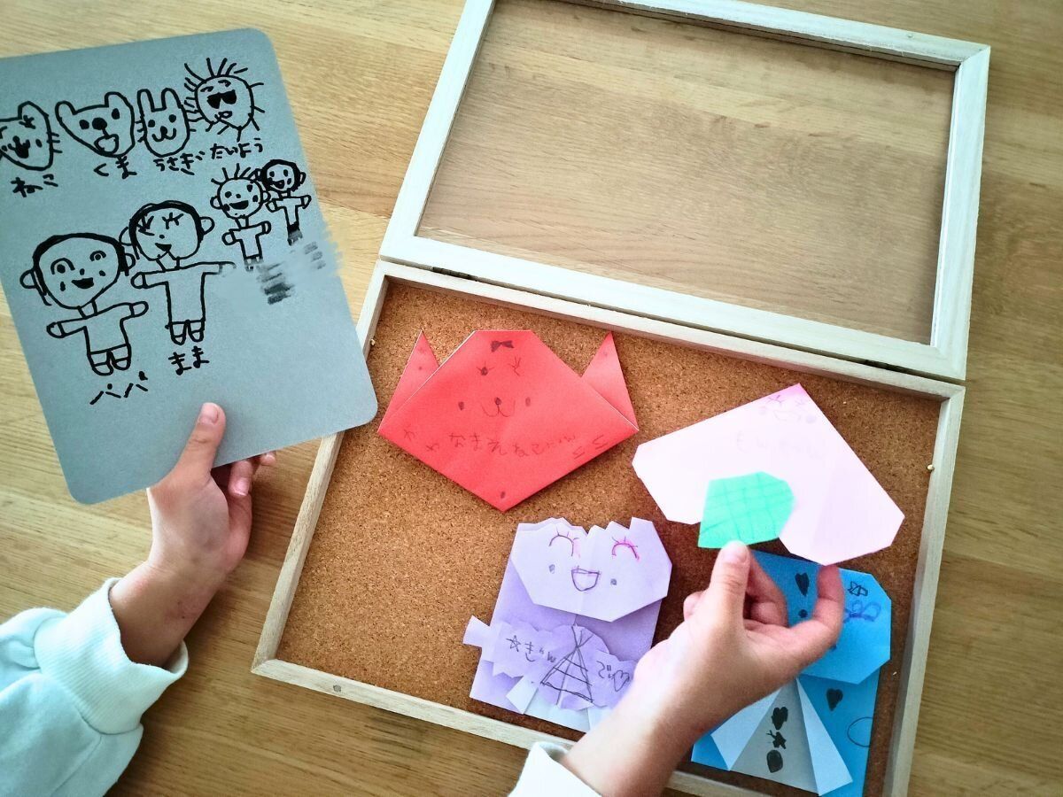 額に入れる作品を選ぶ娘