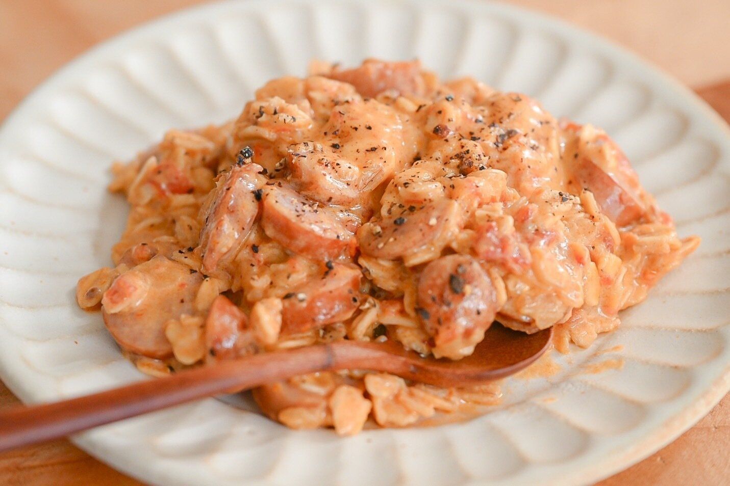 陶器の皿に盛られたオートミールのトマトクリームリゾット