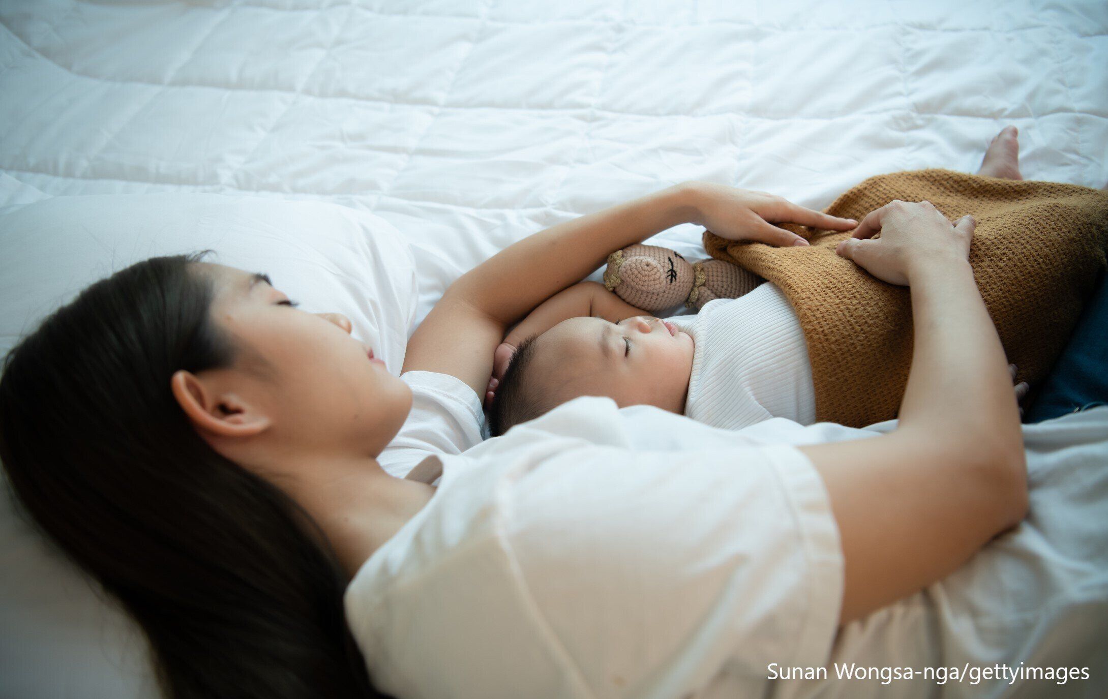 赤ちゃんに添い寝する母