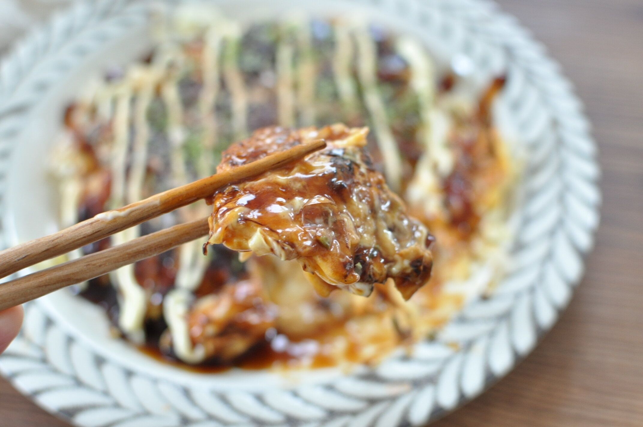 餅お好み焼きを箸で持ち上げている様子