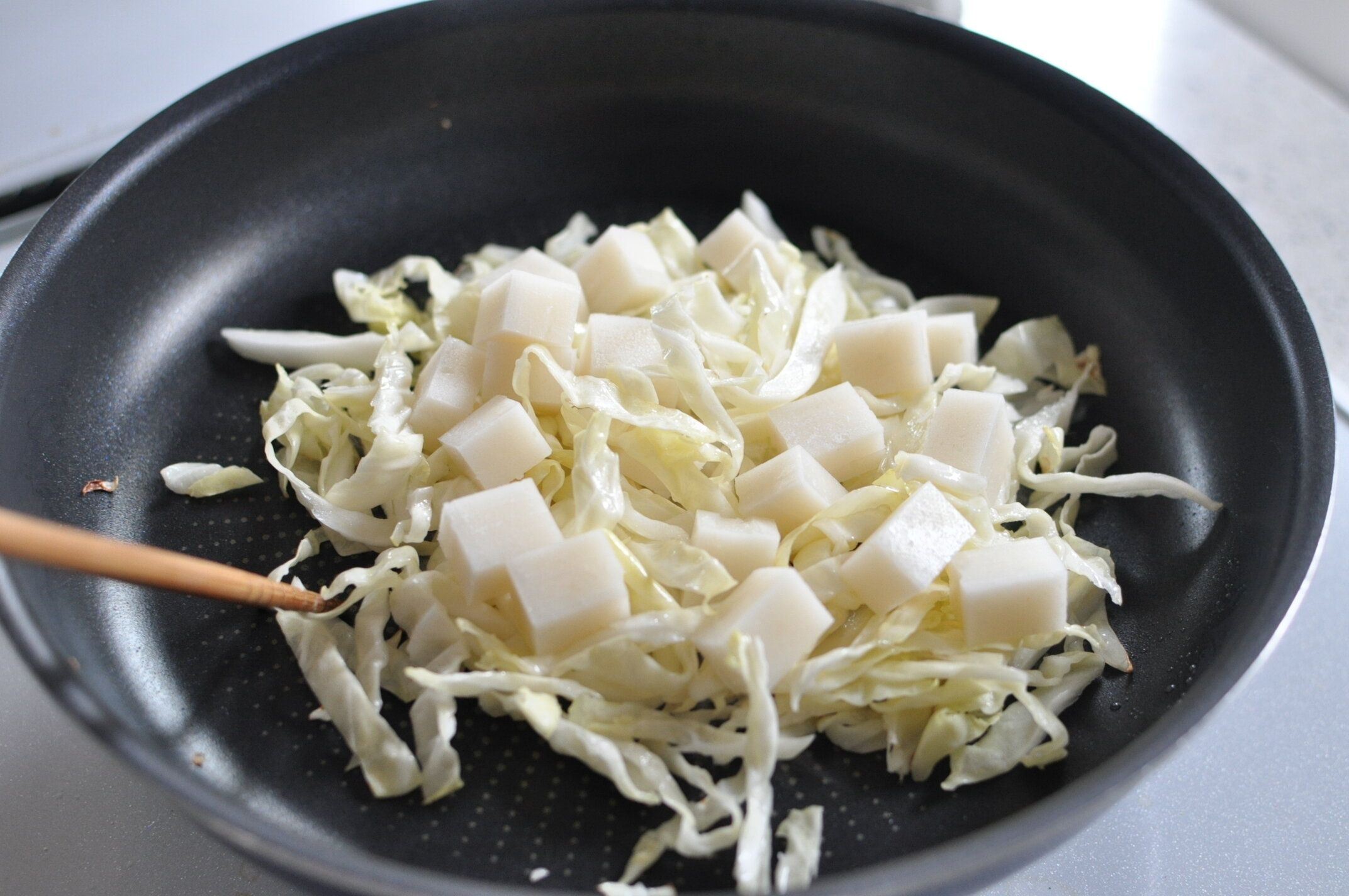 炒めた千切りキャベツに餅をのせた様子