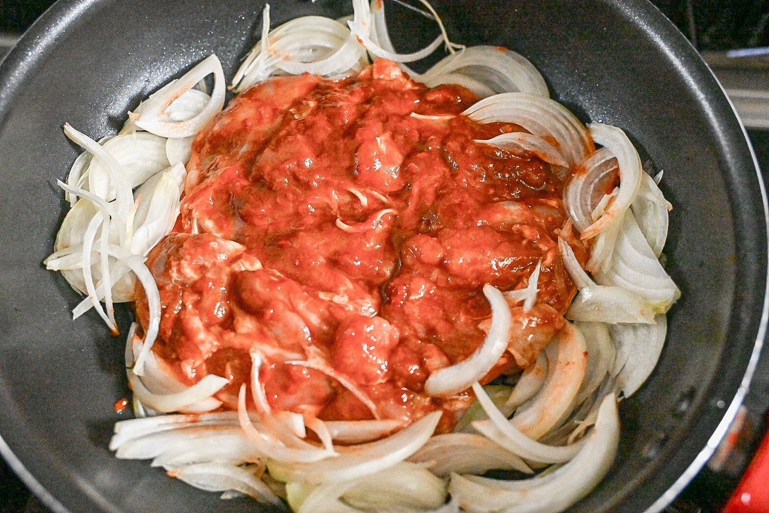 フライパンに入った加熱前のケイジャンチキン