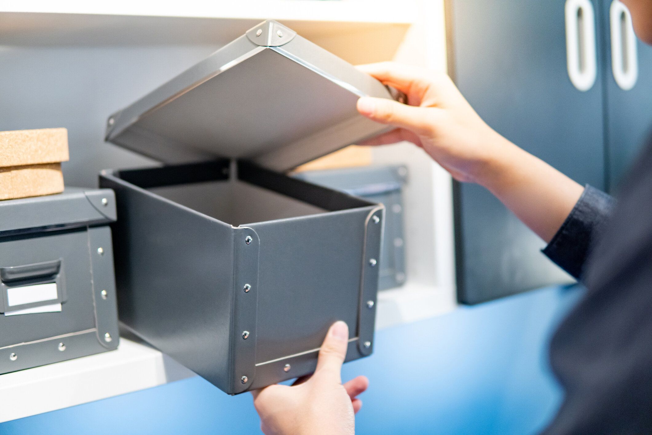 棚の男性の手の開口部灰色の紙箱