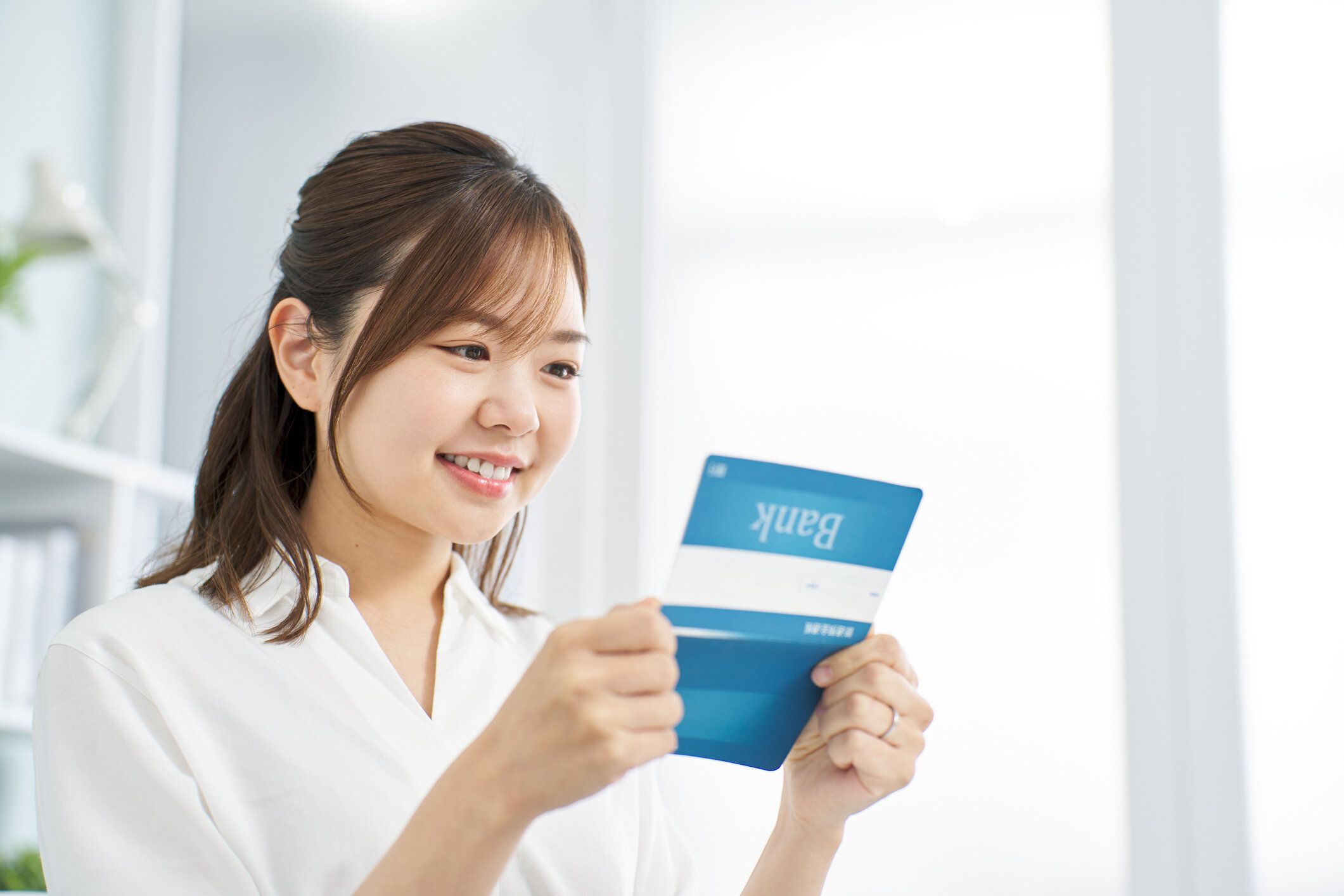 笑顔で通帳を眺める女性