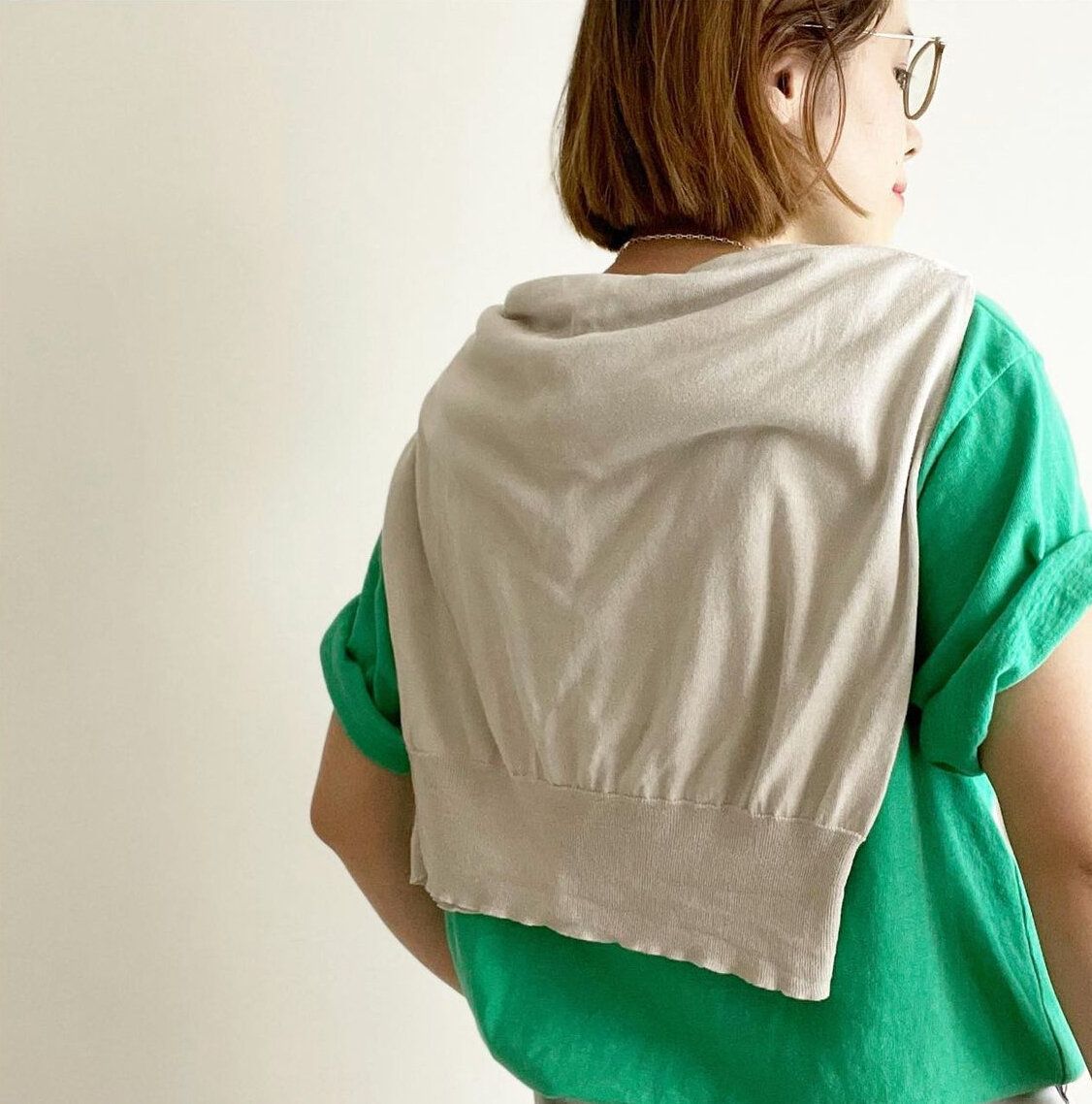 ベージュカーディガンを肩がけ