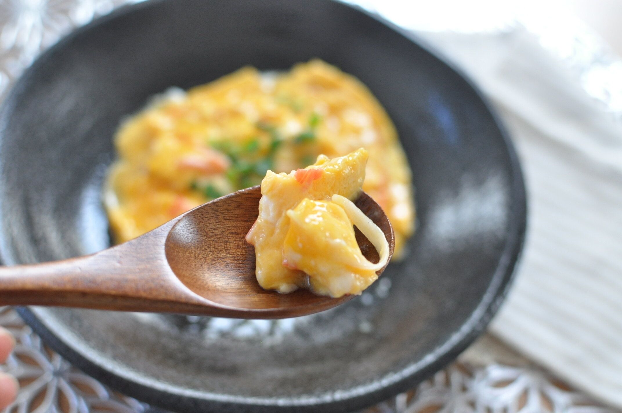 かに玉を木のスプーンですくった様子