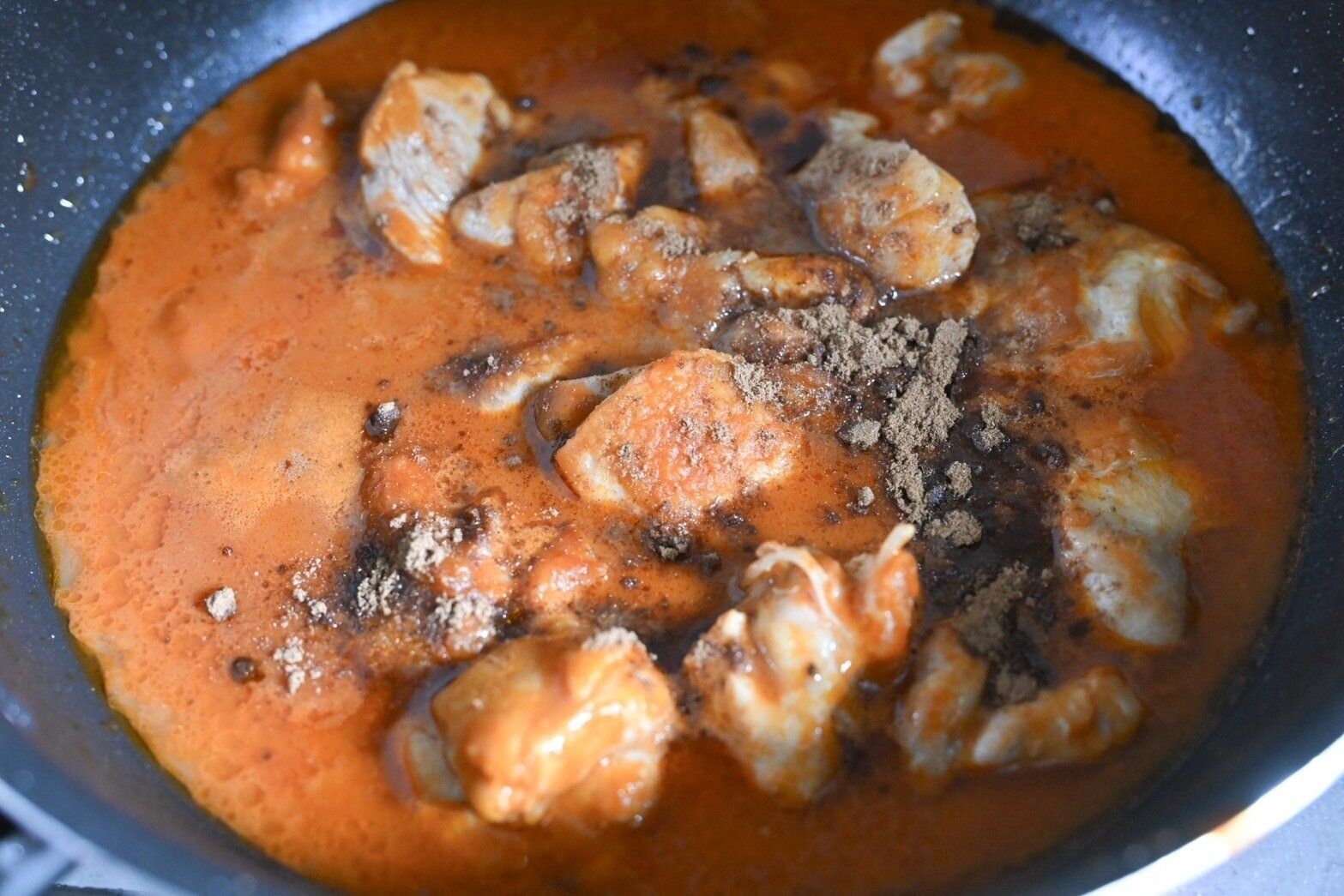 鍋に入ったガラムマサラを入れたバターチキンカレー