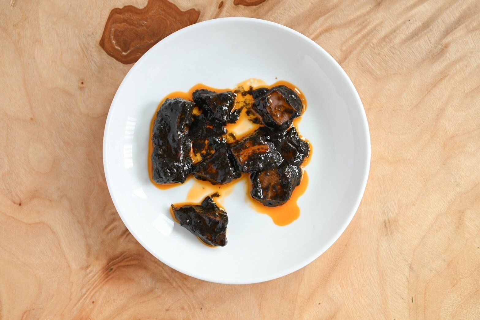 白い皿にのったイカのスミ煮