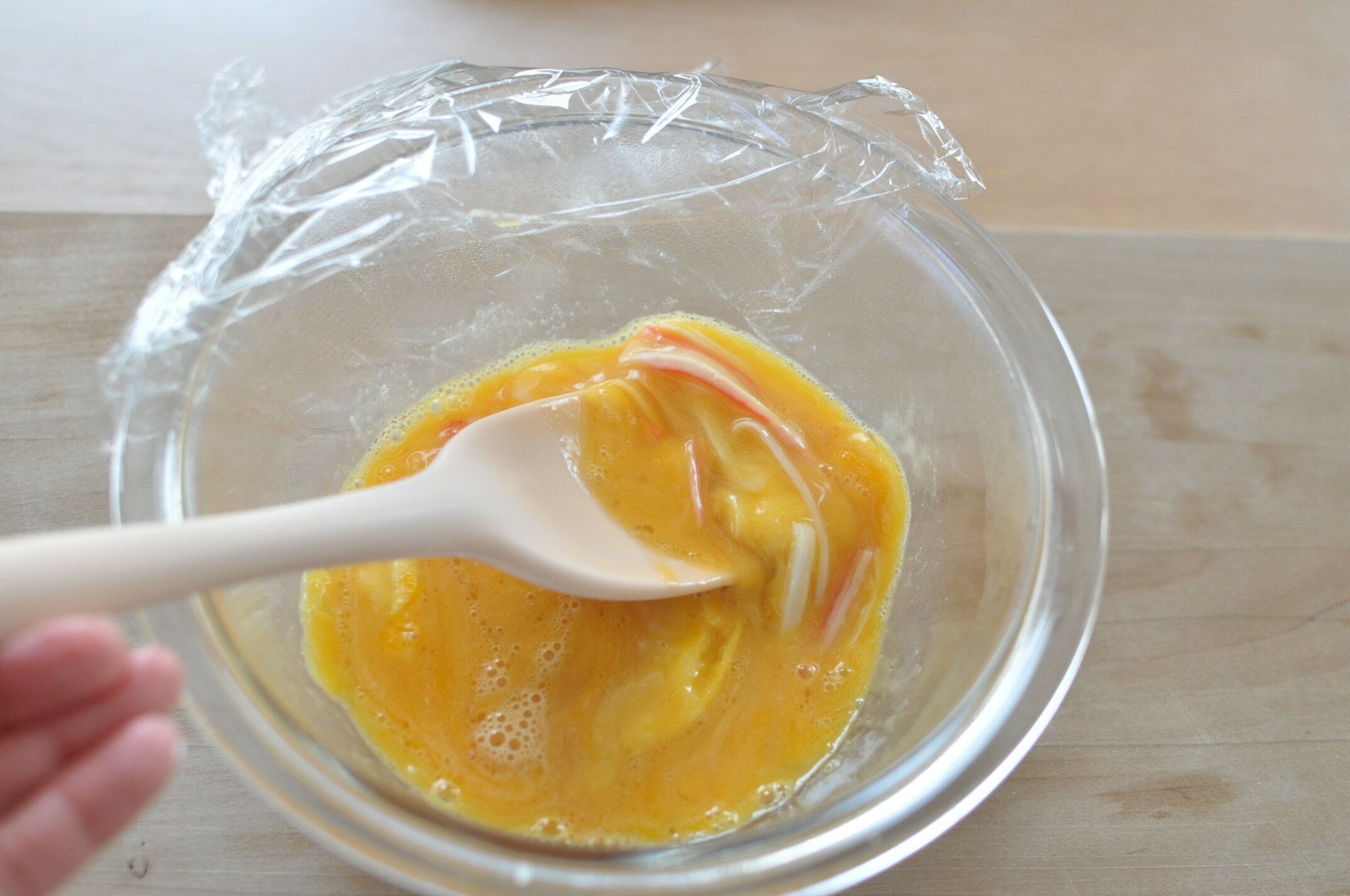 固まった卵をゴムベラで軽く混ぜる様子