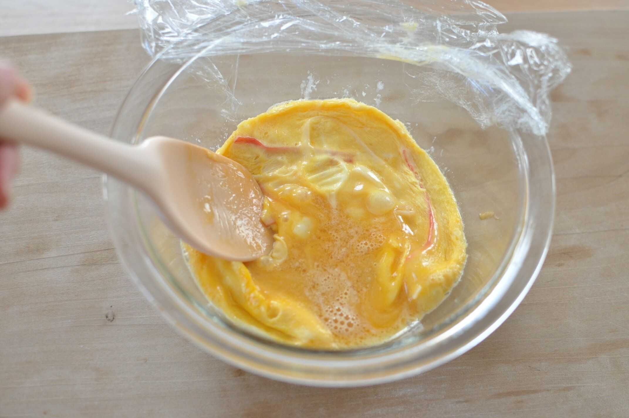 さらにレンジで加熱して固まった卵をゴムベラでほぐす様子