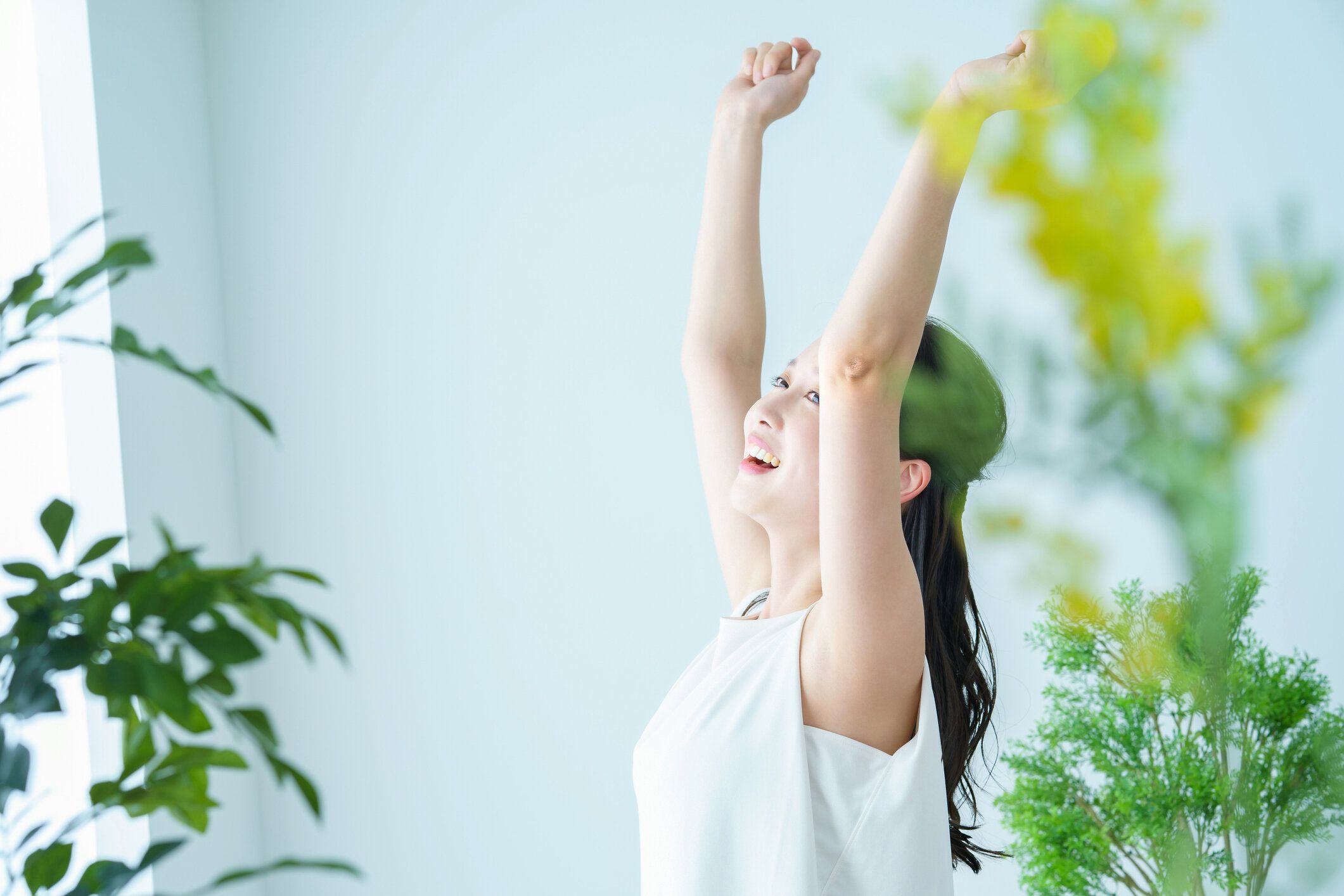 光を浴びながら深呼吸をする女性
