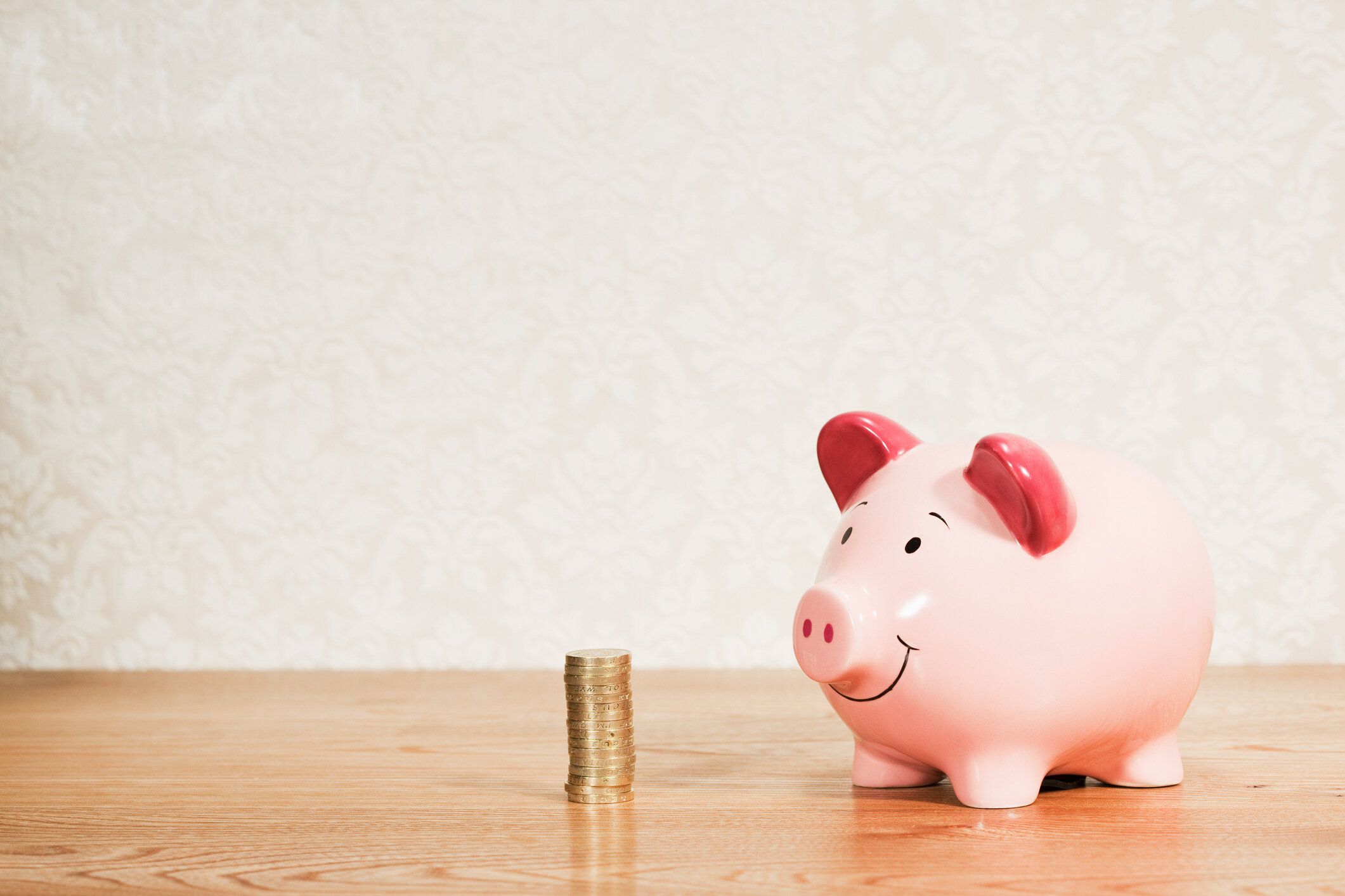 ブタの貯金箱とスタックのポンドの硬貨