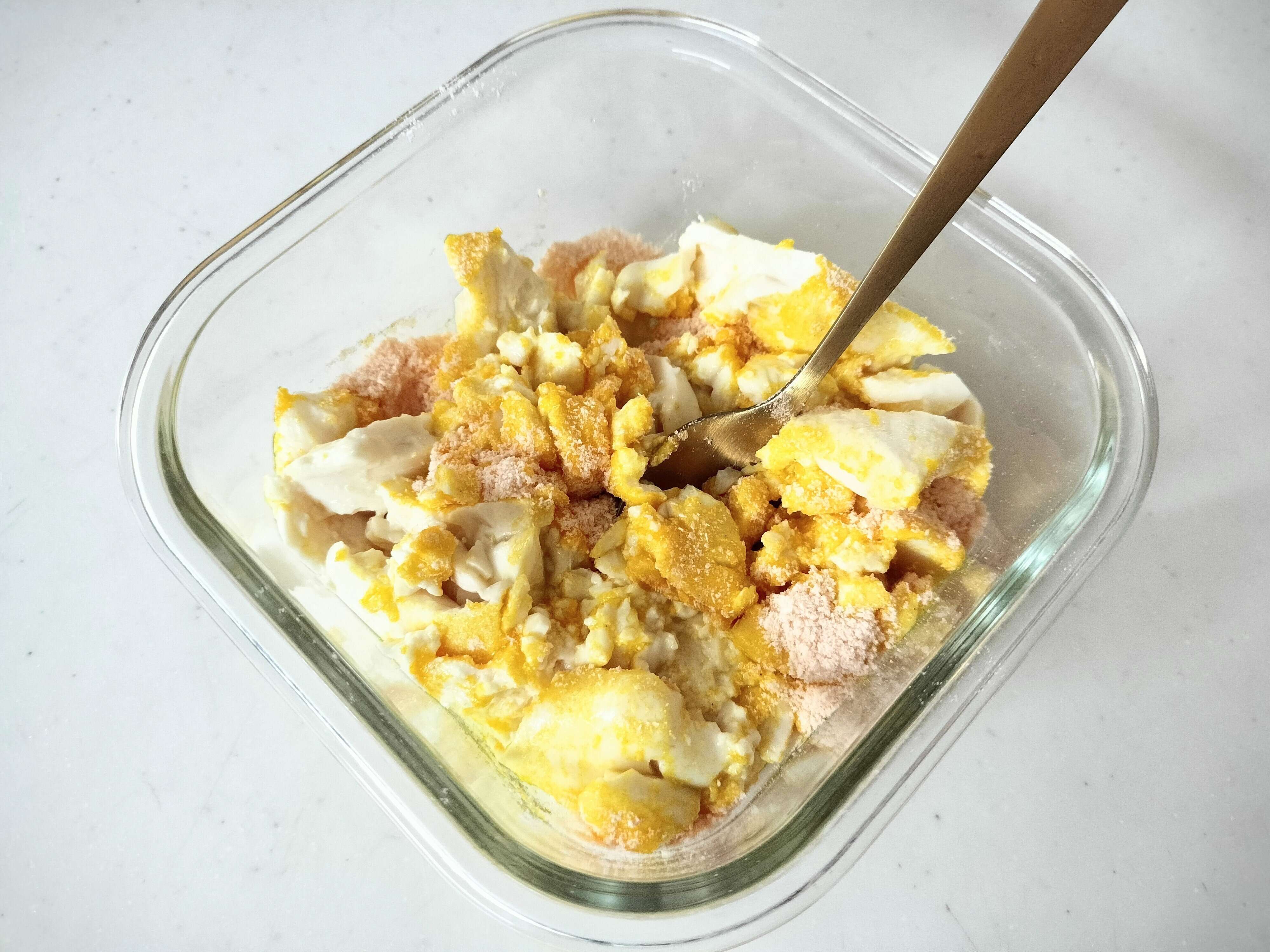 豆腐に素を入れてよく混ぜる様子