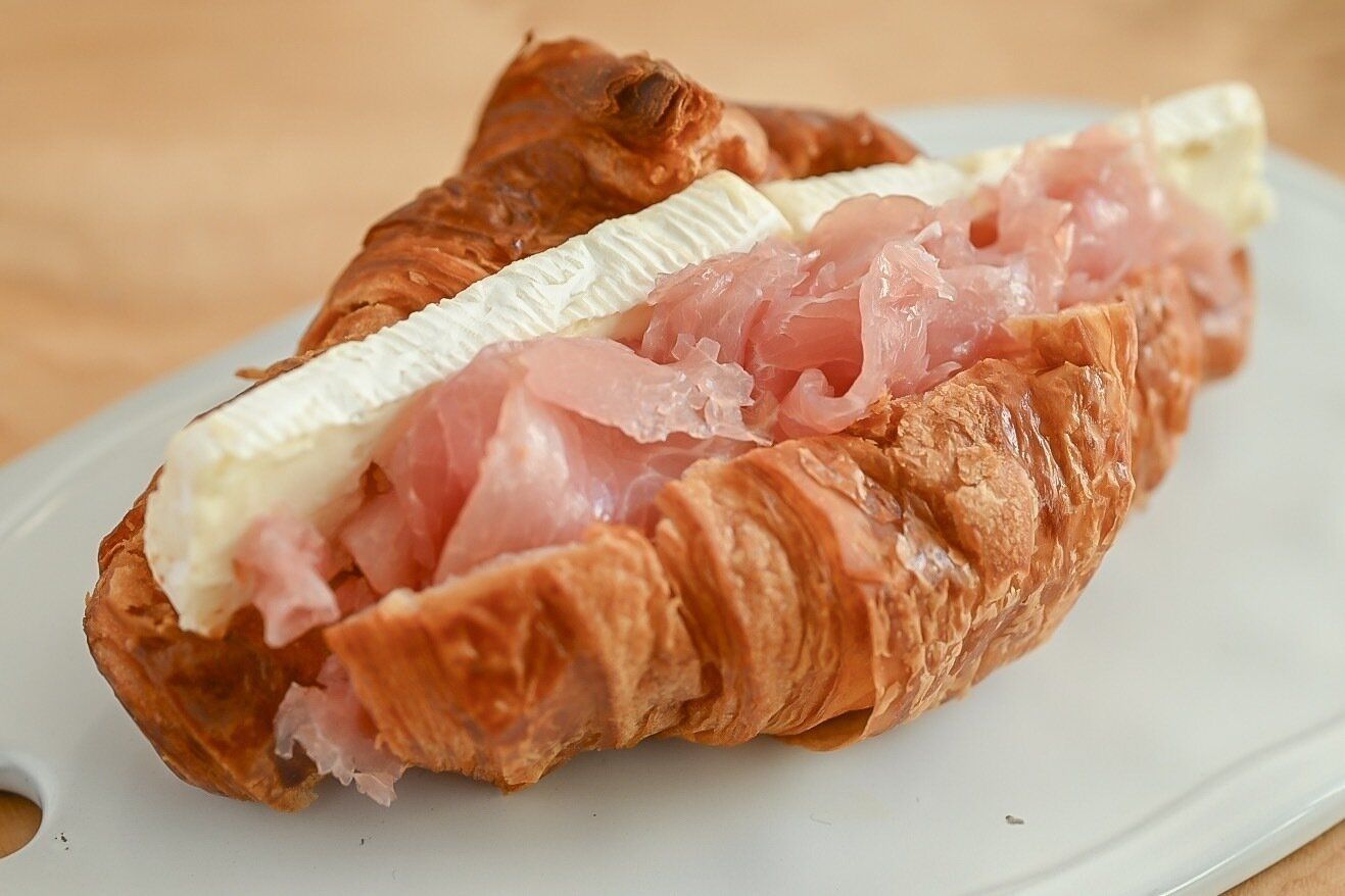 皿に盛られた生ハムとカマンベールチーズのクロワッサンサンド