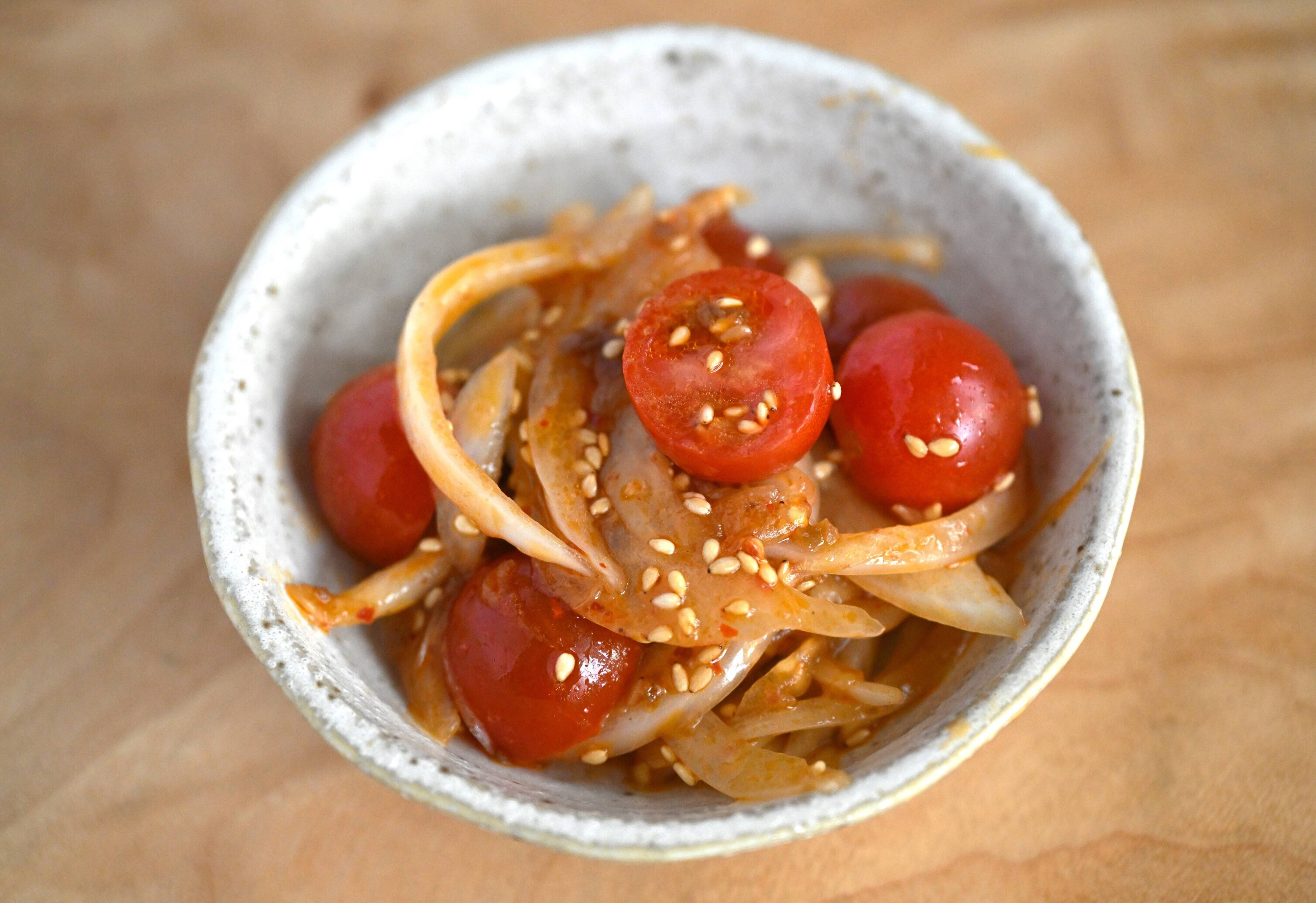 皿に盛られたミニトマトと新玉ねぎの坦担サラダ