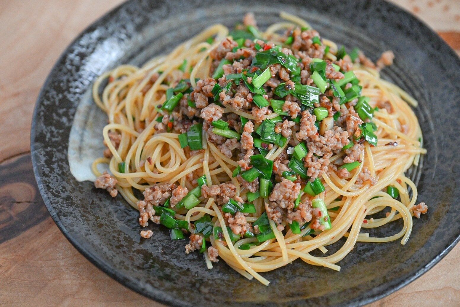 黒い皿にのった中華パスタ