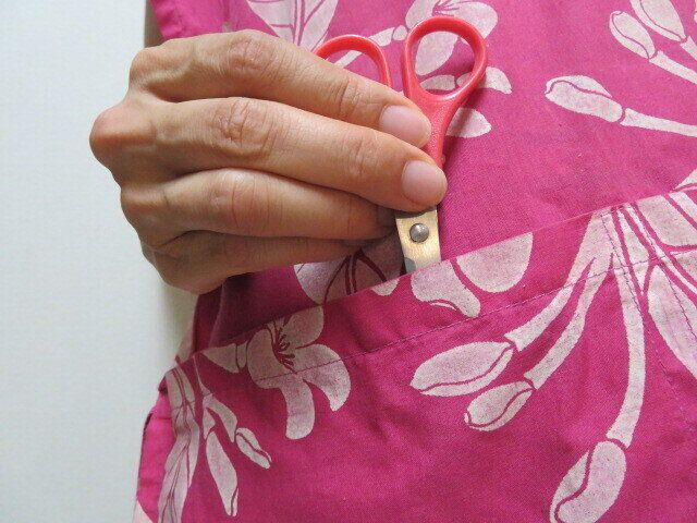 ハサミをエプロンに入れる