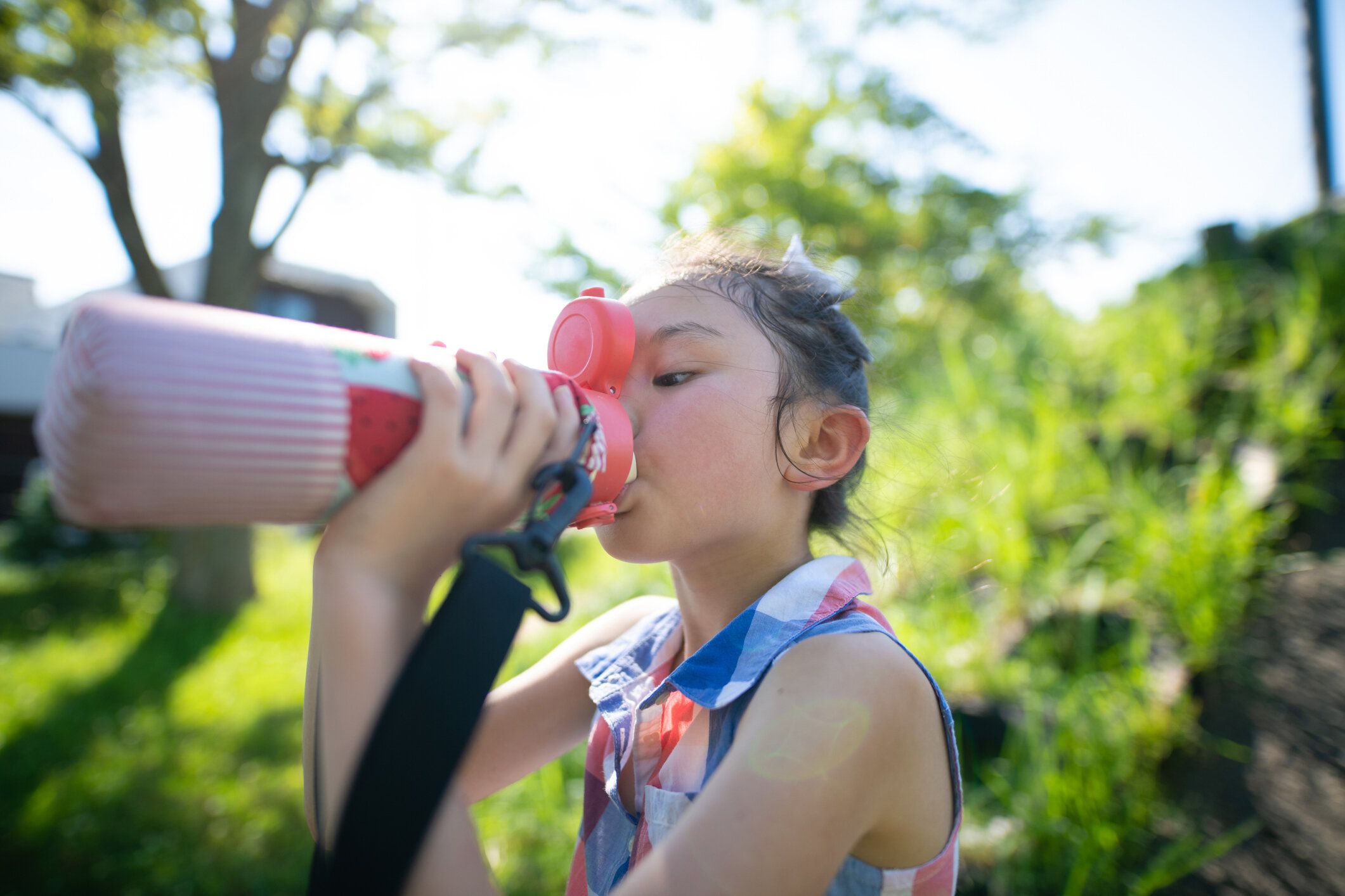 水筒から水を飲む女の子