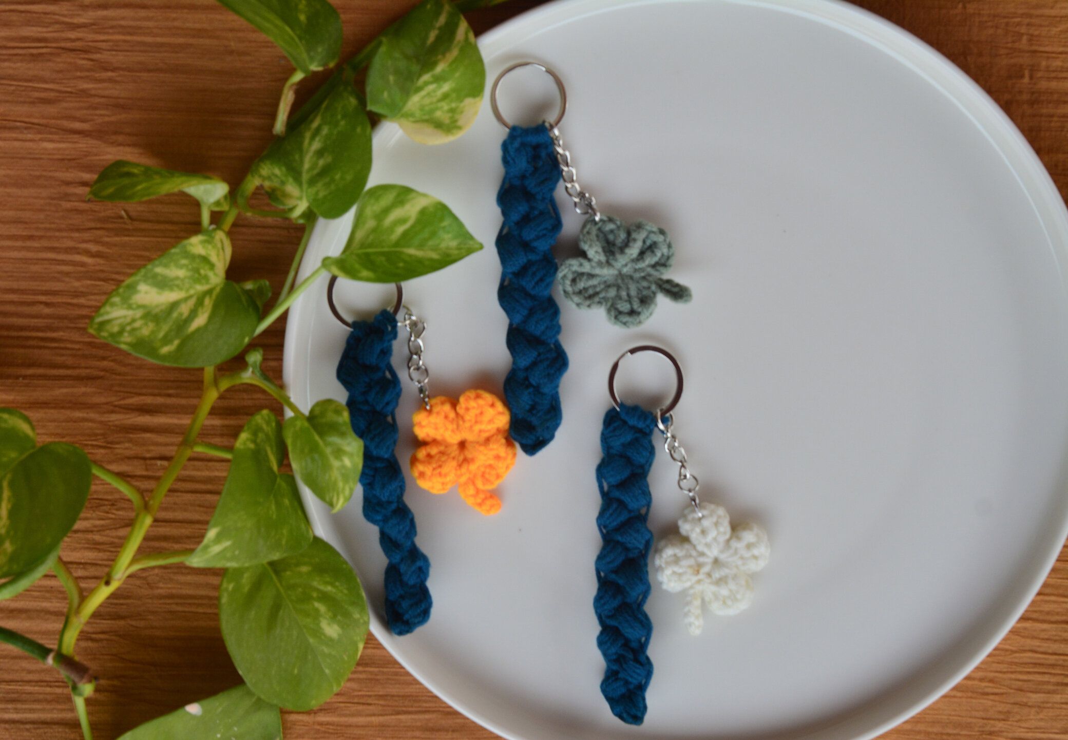 白と茶色の背景に手作りのカラフルかぎ針編みのシャムロックキーホルダー、カラフルかぎ針編みのシャムロック、ラッキーチャーム