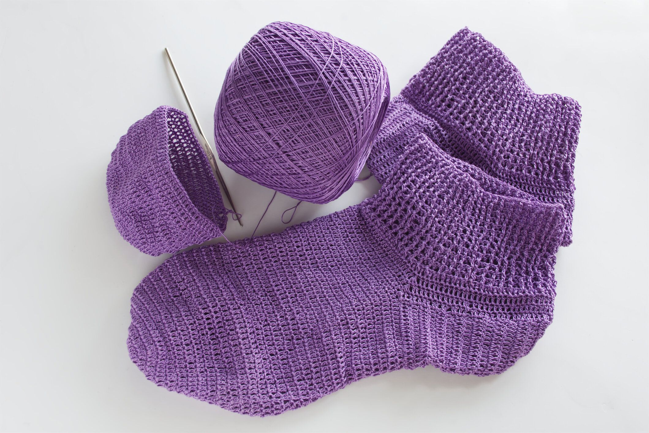 紫色の糸から作られた靴下。かぎ針編みが好きな人に人気のクラフトです。