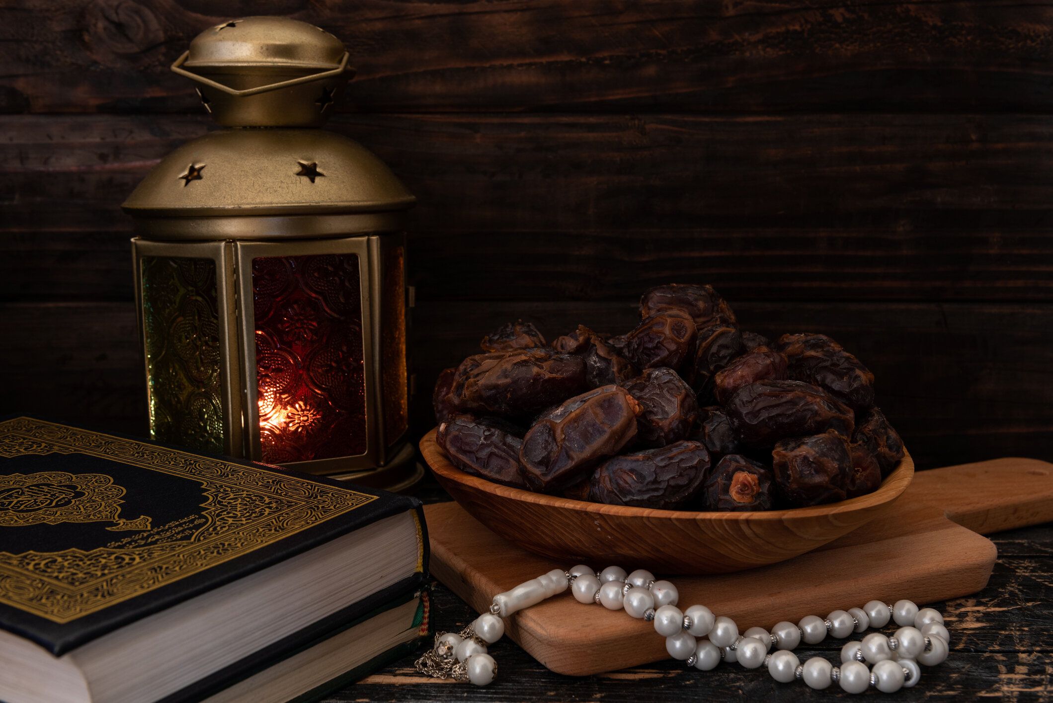 木製の皿、ロザリオビーズ、聖クルアーン、ランタンに入った乾燥ナツメヤシまたはクルマ。