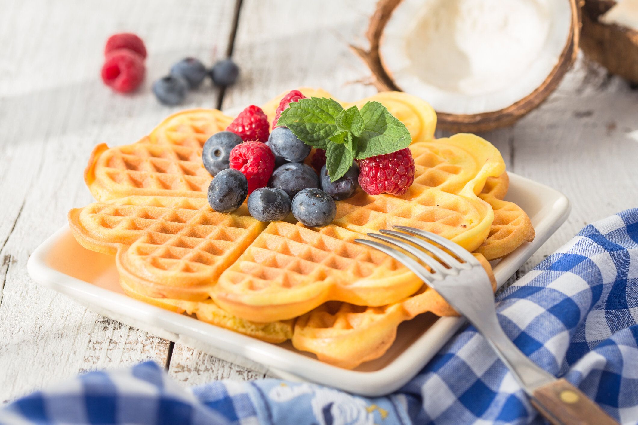 ベリーの素朴な背景トップビューでトペストハートの形をした自家製ココナッツミルクワッフルと朝食用のテーブルセット